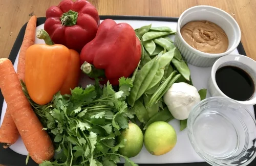 Heres what you need... for a double recipe. 8-10 boneless skinless chicken thighs, a couple of carrots, 3-4 red and orange peppers, snow peas, garlic, limes, soy sauce, natural peanut butter, white vinegar and brown sugar and cayenne pepper (not pictured). I also added cilantro and green onion.