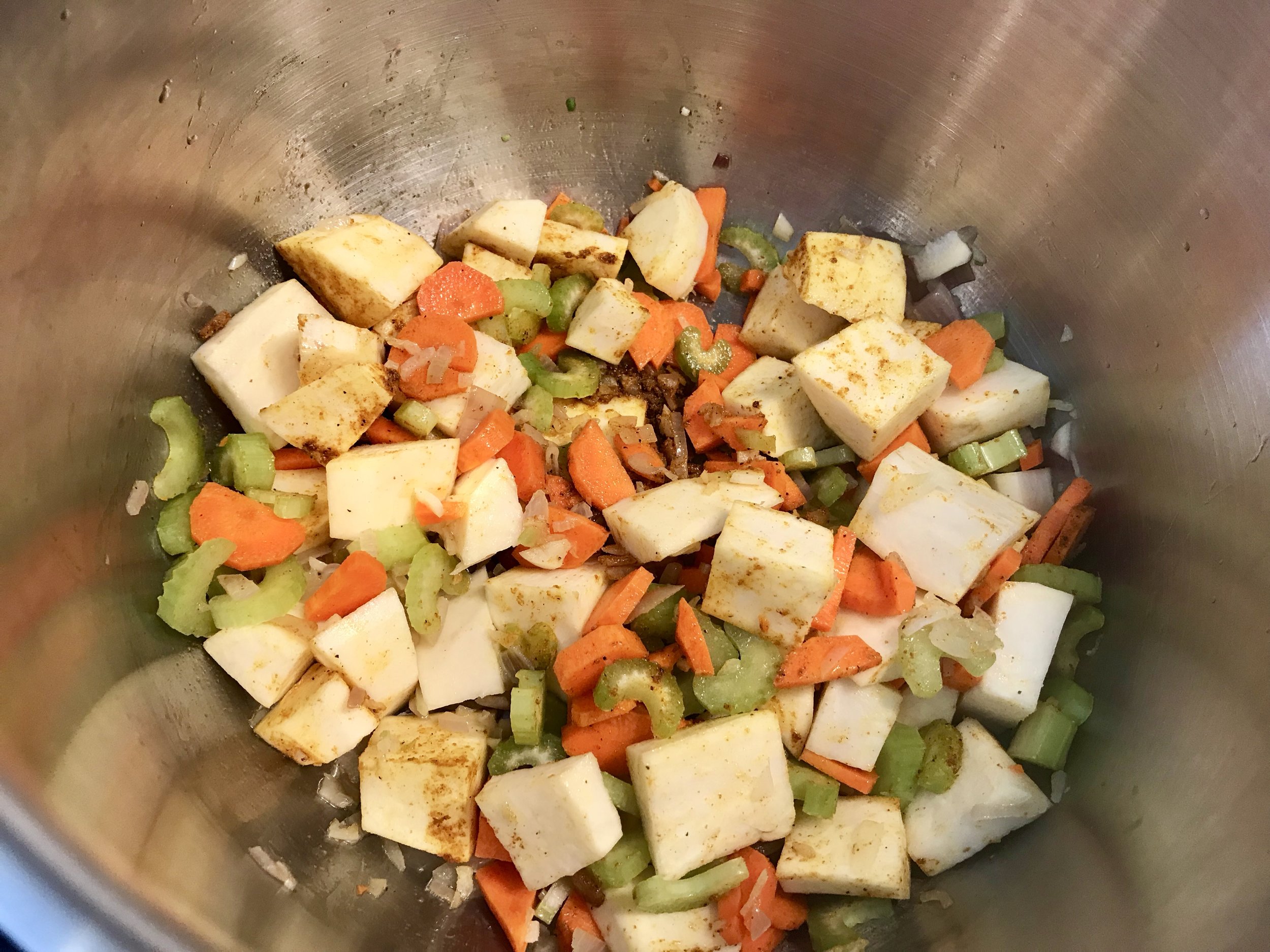 I used a lighter sweet potato here. You can use a combination of the white and orange variety or try all orange sweet potato. Add all the veggies and spice and saute’ for a minute and then add the broth or water.