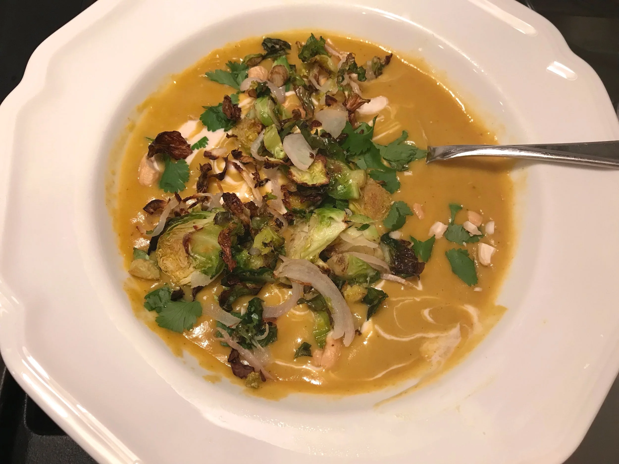 Add the coconut cashew cream and cilantro and even a couple crushed cashews for a garnish. Here, I added leftover roasted vegetables!