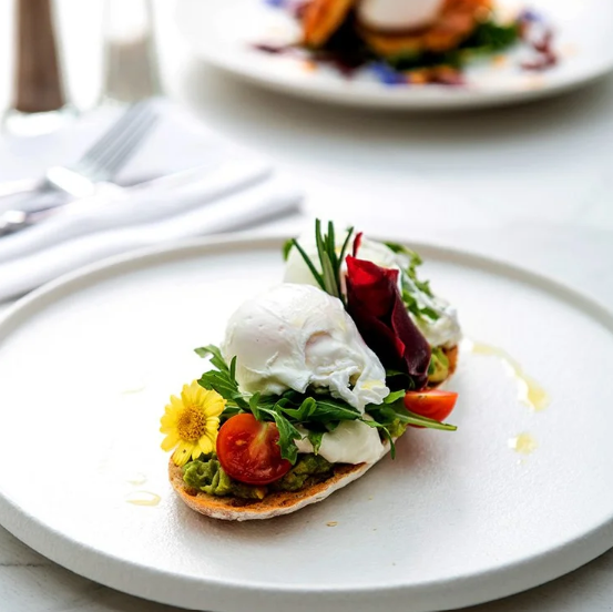 Poached eggs with smashed avocado, cherry tomatoes and fresh herbs at Islington Hotel, Hobart