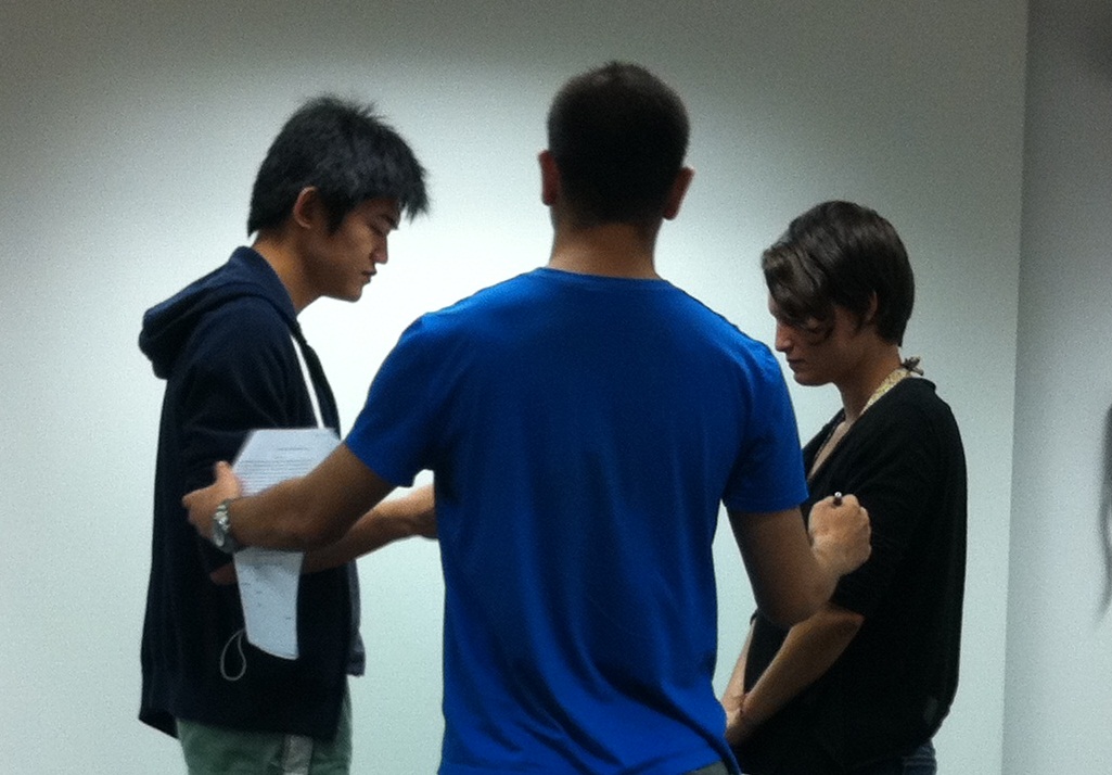 Workshop/NYU: co-director Wesley Aroozoo (center) with Ethan Chia (left) and Olivia Briggs in rehearsal for OMEN ROAD TO STARRVILLE by Erik Champney.