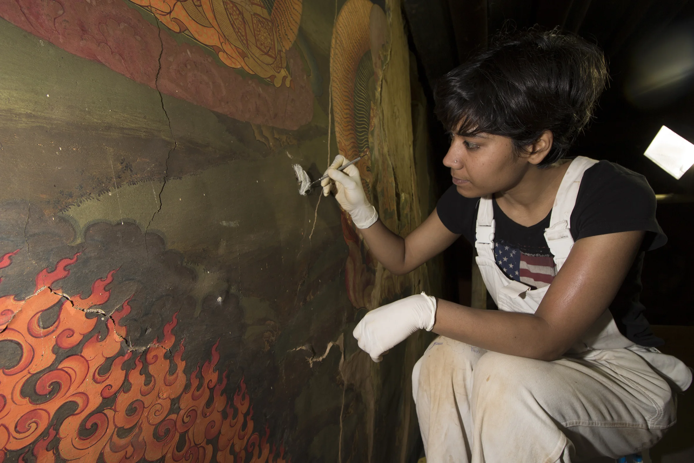 Kalpana temporarily stabilises a fragile fragment with gauze and cyclododecane at the Tango Monestry, Bhutan.
