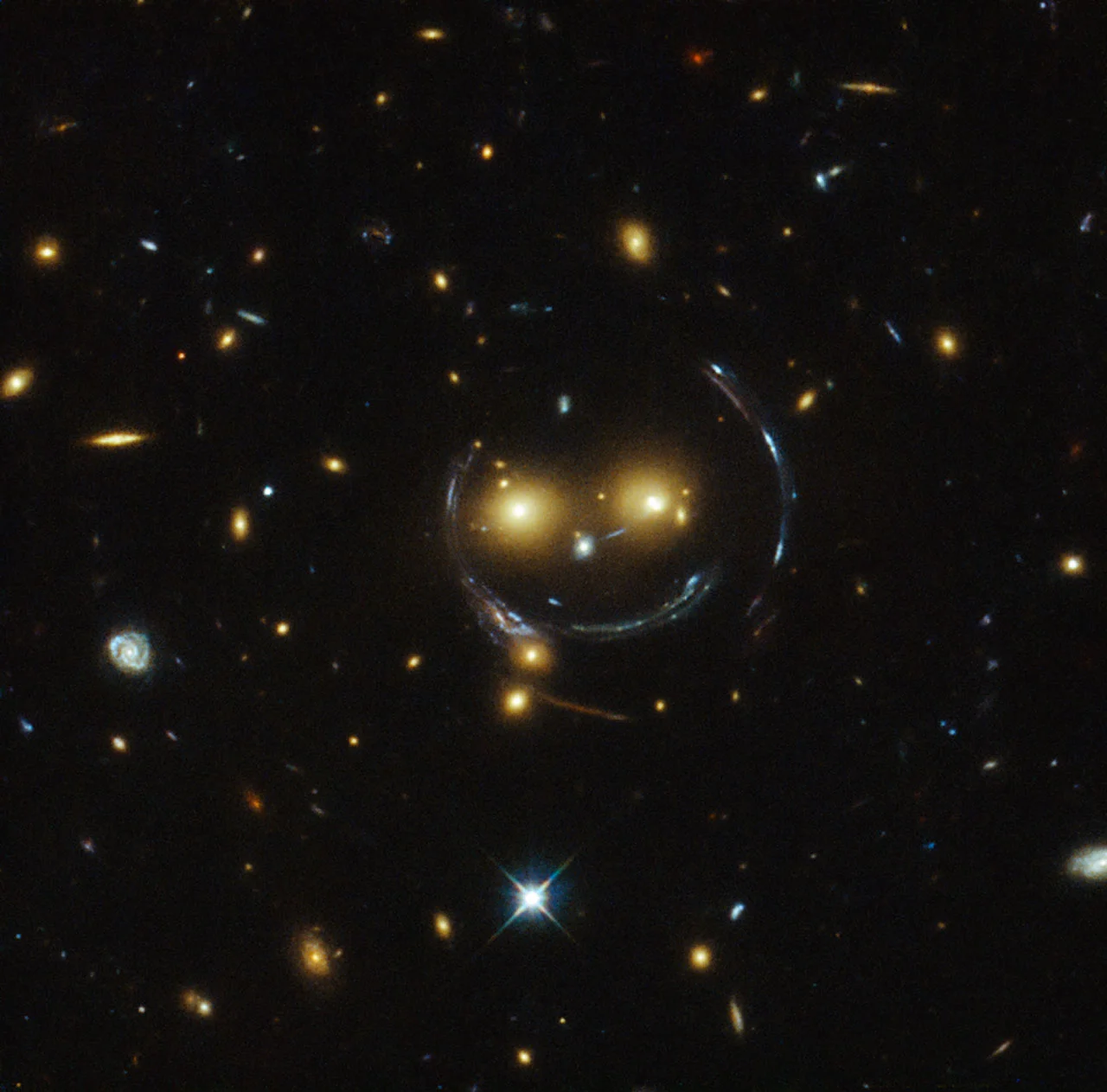 The galaxy cluster SDSS J1038+4849, which shows the distortions of background galaxies caused by gravitational lensing.Photo Credits: NASA/ESA Hubble Space Telescope.&nbsp;