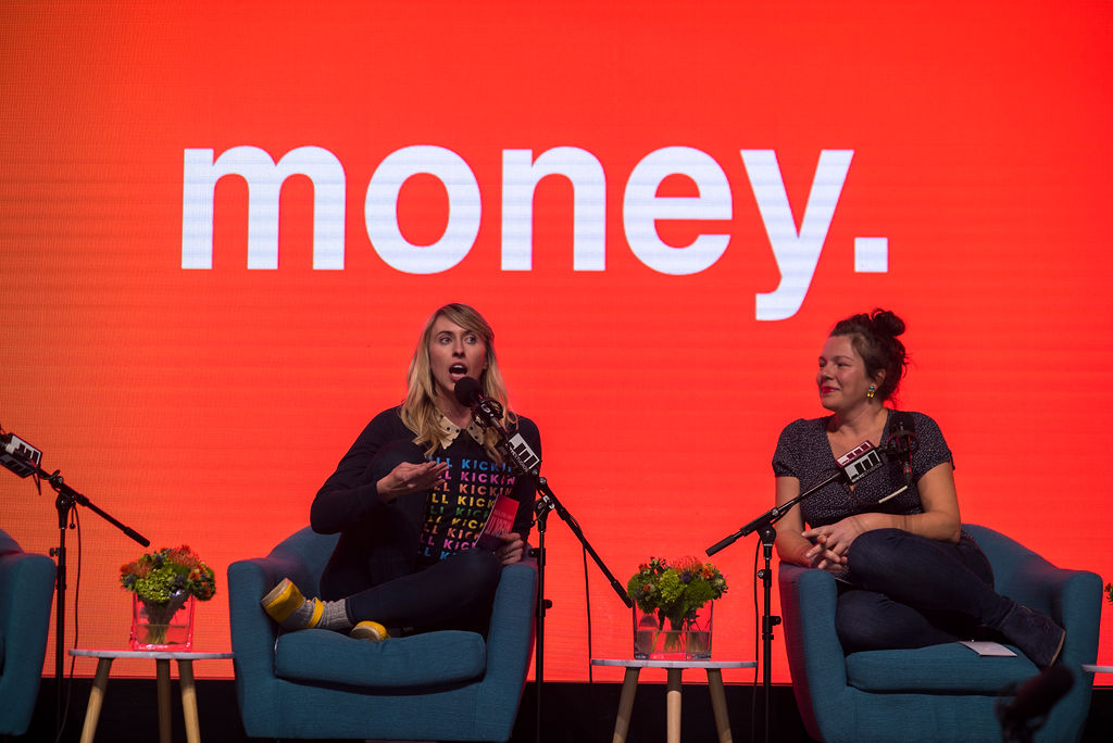 Nora McInerny and Ami Spishock on stage seated behind microphones