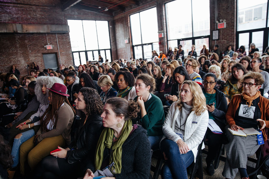 Audience members seated watching a presentation