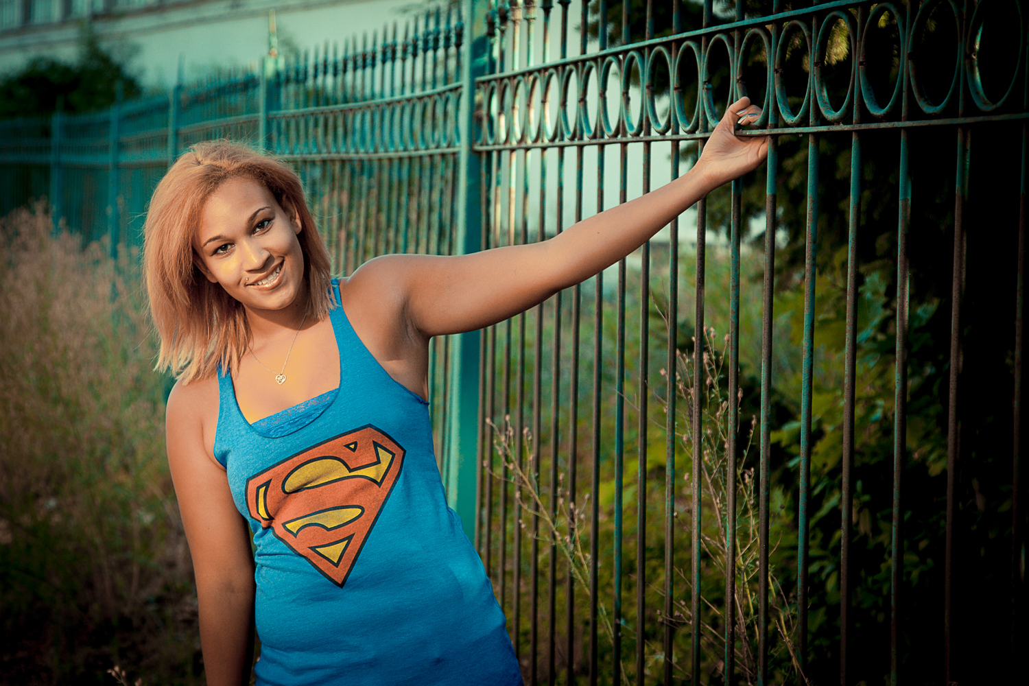 Portrait-HIgh-School-Seniors-young-woman-holding-onto-a-fence-with-superman-tshirt-024.jpg