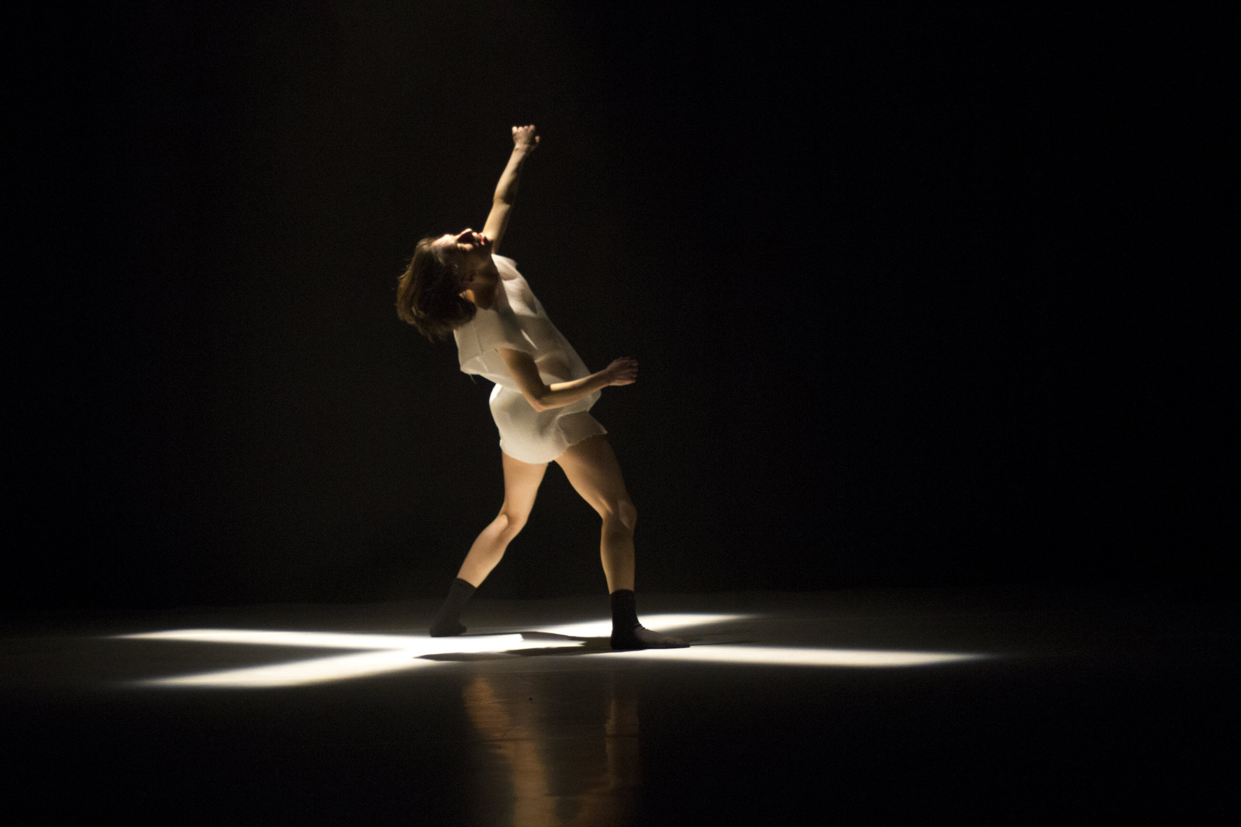 Photo: Ben Didier Container "A visceral solo dance bursting out of a starkly abstract stage and costume design. Goodman's character is born into a rectangle of light, moves powerfully but haltingly through the darkness, and then returns to the light. One-line review: Goodman moved to the industrial-ambient music like one of its notes made flesh in a way that elicited from me an audible and unbeckoned "damn" at the end of the performance." Rich Smith/The S tranger (2016) "As I reflect the opening weekend of NWNW Festival, there are three performances that struck a cord with me. And got me excited about PNW arts again. The first being Vanessa Goodman. Vanessa Goodman: She is what others try to be when it comes to contemporary dance and performance. Musicality, physicality, spiritual, control, articulation, loss of control and joy. She could have easily been lost on the Mainstage , but she easily made the stage her willing and small partner." Dani Terrill/On the Boards Blog (2016) "Goodman's solo Container, a version of which she presented earlier this June at the Magnetic North Festival, showcases what an amazing mover she is. Clad in nude-coloured dance semis and what looked like mini combat boots, and combining hyper-kinetic android-like movements with various club grooves, Goodman reminded me at various points of a cross between Priss from Blade Runner and Miley Cyrus--but without the look-at-me twerking, and with a much more gorgeous silhouette. At one point, early on in the piece, Goodman launches into a deep lunge, arching her back in way that had me wishing I could mimic that pose on the beach. Then, too, there is Goodman's innate musicality, as when she pulses her upper body and arms in simple yet hypnotic time to the electronic sound score by Loscil (the Vancouver-based artist Scott Morgan). To go back to that sci-fi connection I made via the Blade Runner reference, Container ends with Goodman dancing in a single, slowly fading spot upstage (the lighting is again by Proudfoot), her upper body raised to the ceiling as if she is about to be transported to another world, one that is big enough to contain her outsized talents." Peter Dickinson/Performance, Place and Politics (2015) "Now to casually and swiftly change subject: Vanessa Goodman. Peter Dickinson writes: “Container ends with Goodman dancing in a single, slowly fading spot upstage… her upper body raised to the ceiling as if she is about to be transported to another world, one that is big enough to contain her outsized talents.” Yes. Her “outsized talents.” For a petite, compact woman (she stands right below my chin), she is a lanky, sinew-y, and precise monster on the stage. Ones bones may dictate size, but holy, talent and energy abounds. Watching Container I felt a foreign feeling in my viscera. I often watch professional dancers whom I respect, Goodman being one of them, but rarely do I feel an excitement in the future of dance, art, and the performer’s career. Goodman sparked this responsive exhilaration in me that posed a friendly challenge. Not a challenge to me specifically, but to the dance world at large: how can the ephemeral art form of dance burn in your mind and be a torch bearer for the universal human desire of progress and understanding? Her stretching limbs, smiling face, and pulsating spine created a score that developed through a cyclical momentum, showing the audience both the triumphs in the failures and the devastation in the laurels. I guess I would say that I feel the excitement a peer would have towards what Goodman creates next. Obviously she and I are of different generations, separated by a multitude of years and experiences, but her welcoming demeanour shone onto the Firehall audience and warmly invited us into her odyssey." "The work presented thus far at Dancing on the Edge has provided hope that our contemporary culture is not using art for social regulation or as a means to a radical end. Dance in Vancouver (if Chambers, Goodman and Hong Kong Exile can serve as vibrant examples) is truly pushing us to an edge where we must build the path as expeditiously as we step forward. If dance rarely comes up as a subfield of “art”, then these works are not scratching out a definition for dance, but redefining what art is. Or they’re just amazing performances that are life-affirming and guide me in carving out a piece of existence; dance is great, and thankfully it can be found everywhere." Ileanna Cheladyn/Dancing on the Edge Blog (2015) "For sheer physical virtuosity, Vanessa Goodman’s Container stood out. Beneath stark lighting from the reliably excellent James Proudfoot, the composer-performer enacted several varieties of anguish at breakneck speed, switching from broken marionette to overwrought club kid to torture survivor with the kind of seeming ease that can only be achieved with intense discipline." Alexander Varty/Georgia Straight (2015)