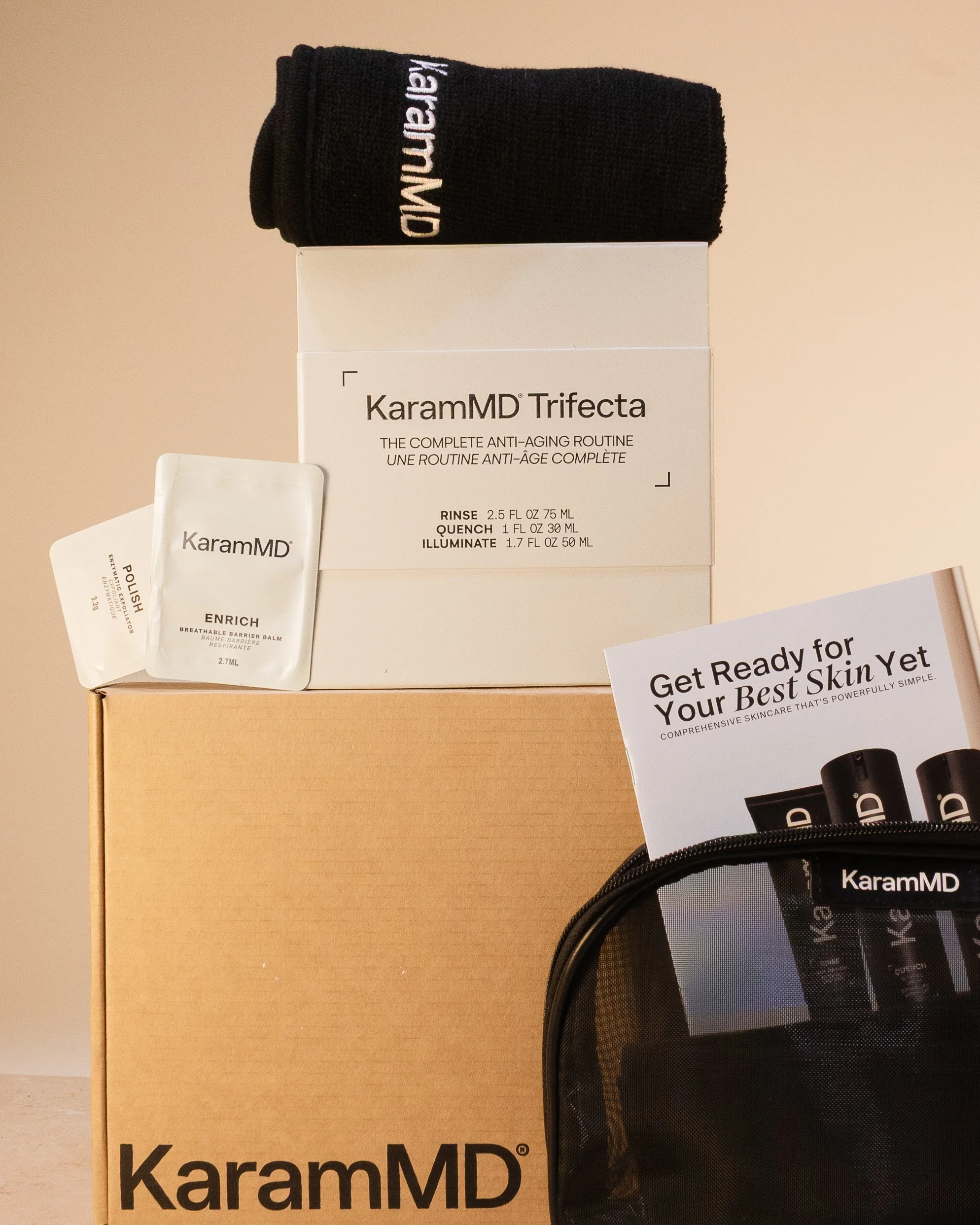 KaramMD skincare products, including a box labeled KaramMD Trifecta with three steps, a small white packet labeled KaramMD, a black pouch with KaramMD branding, and a cardboard box, all set against a plain background.
