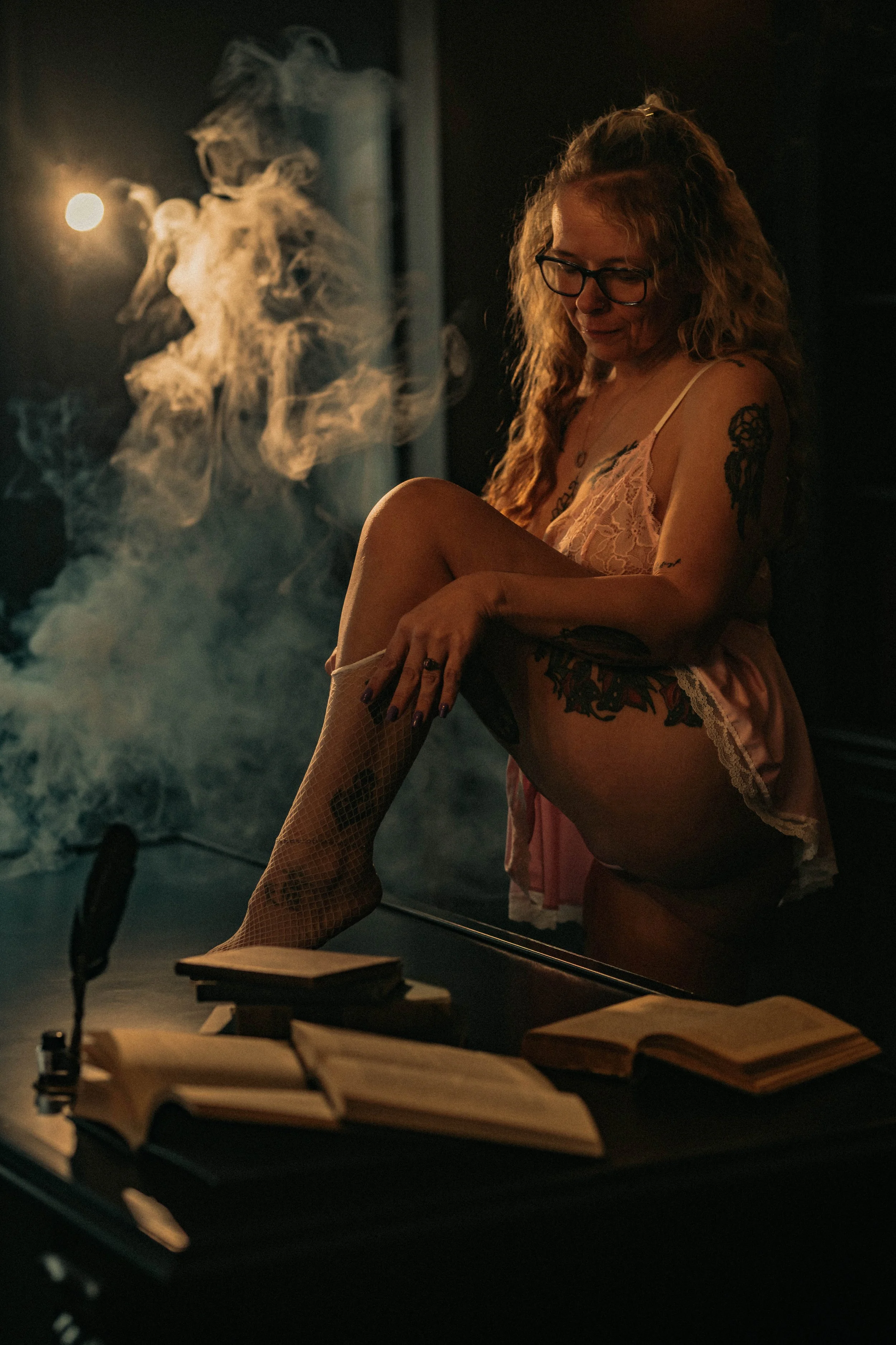 Terre Haute boudoir session with woman in pink lingerie surrounded by smoke in moody studio