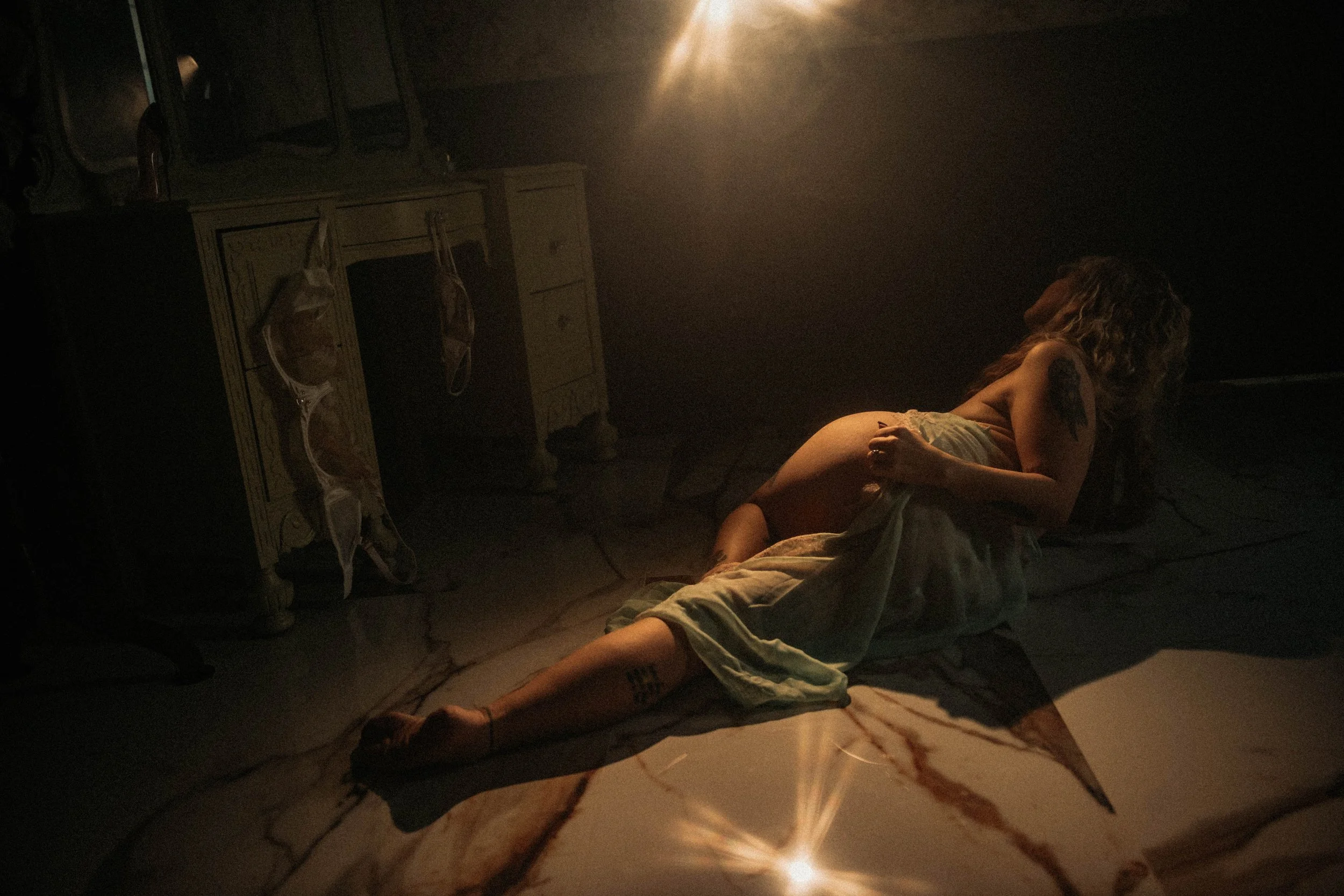 Luxury boudoir portrait in Terre Haute with soft shadows and reclined pose on marble floor