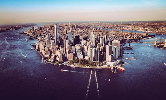 Aerial view of Manhattan, New York City, with skyscrapers and waterways surrounding the island.