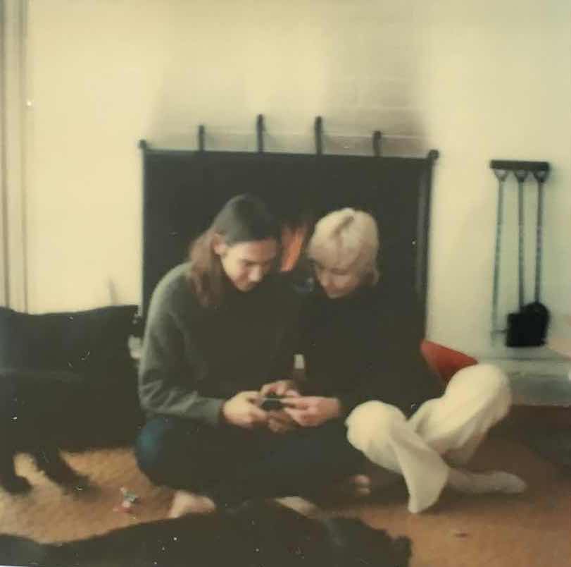 Mrs. Patterson and her son in front of the brick fireplace before it was tiled.