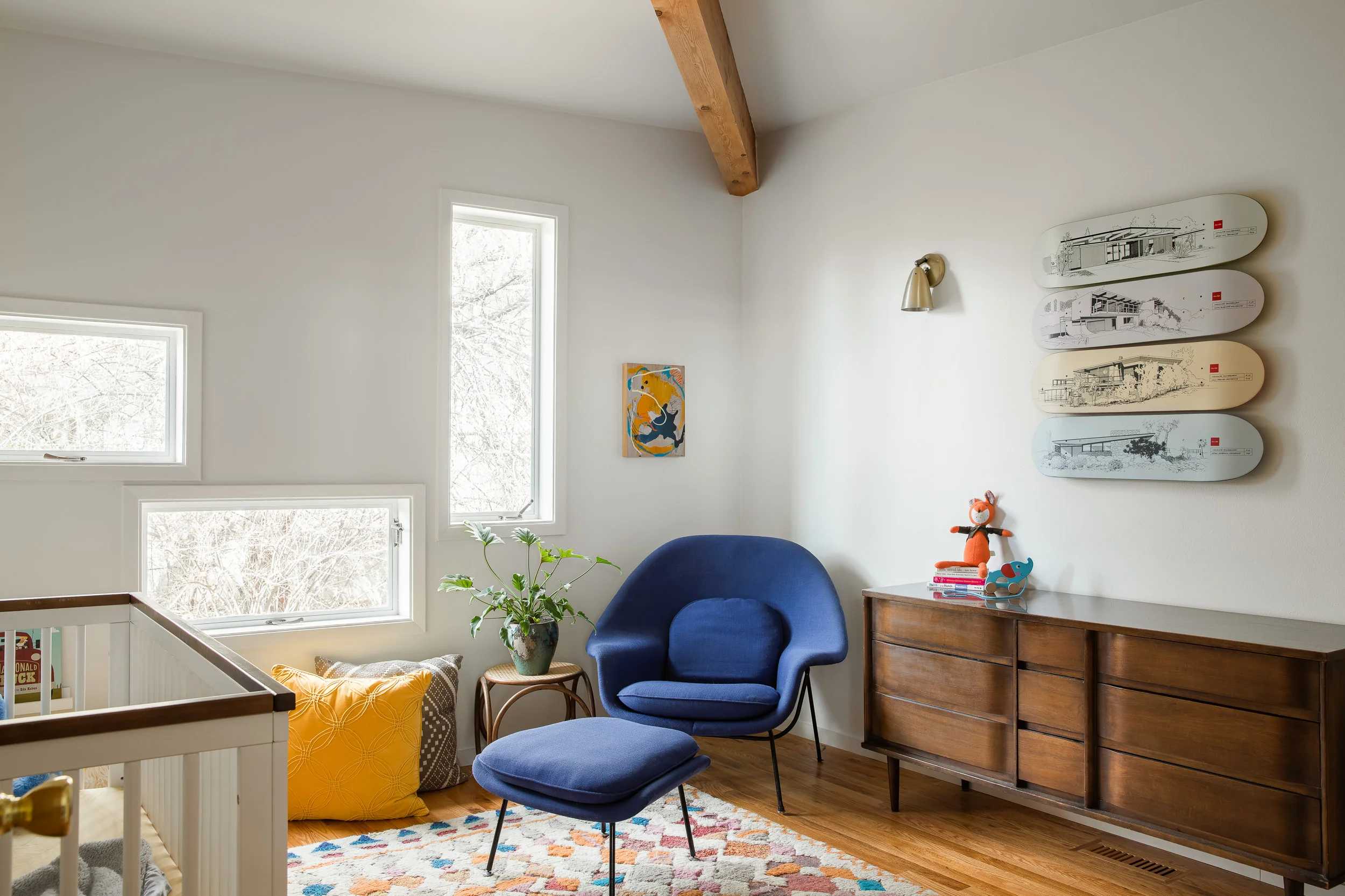 In the nursery, a vintage Knoll Womb Chair sits snugly in the corner on a nuLOOM Moroccan Diamond Multi shag rug , and beside a Thonet ottoman and a vintage dresser. Chocolate Skateboards , designed by Evan Hecox, hang on the wall.