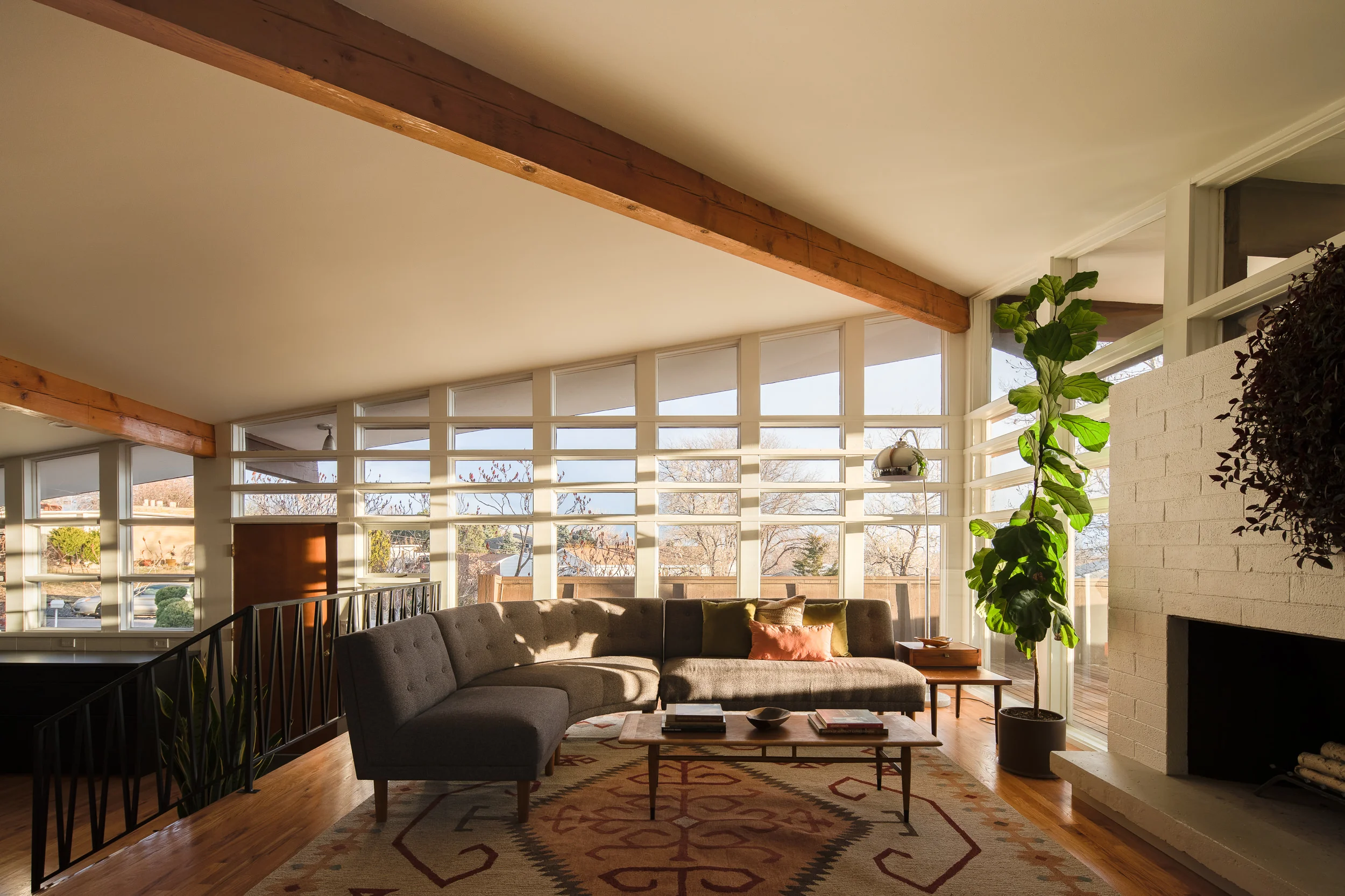 A West Elm Retro Rounded sectional couch hugs a Lane Acclaim coffee table—and the home’s warm light.