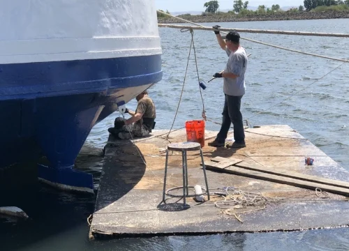 Eric and Chris apply the PSX700 top coat to the lower fantail with brush and rollers.