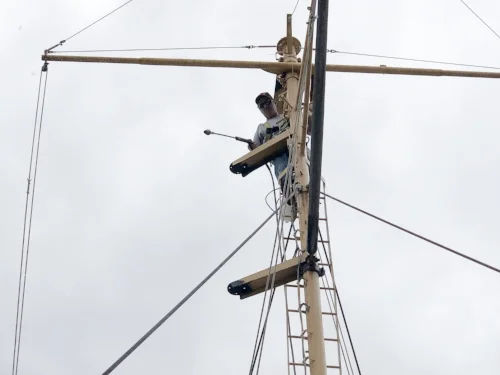 Chris pressure washes the aft mast in preparation for priming.
