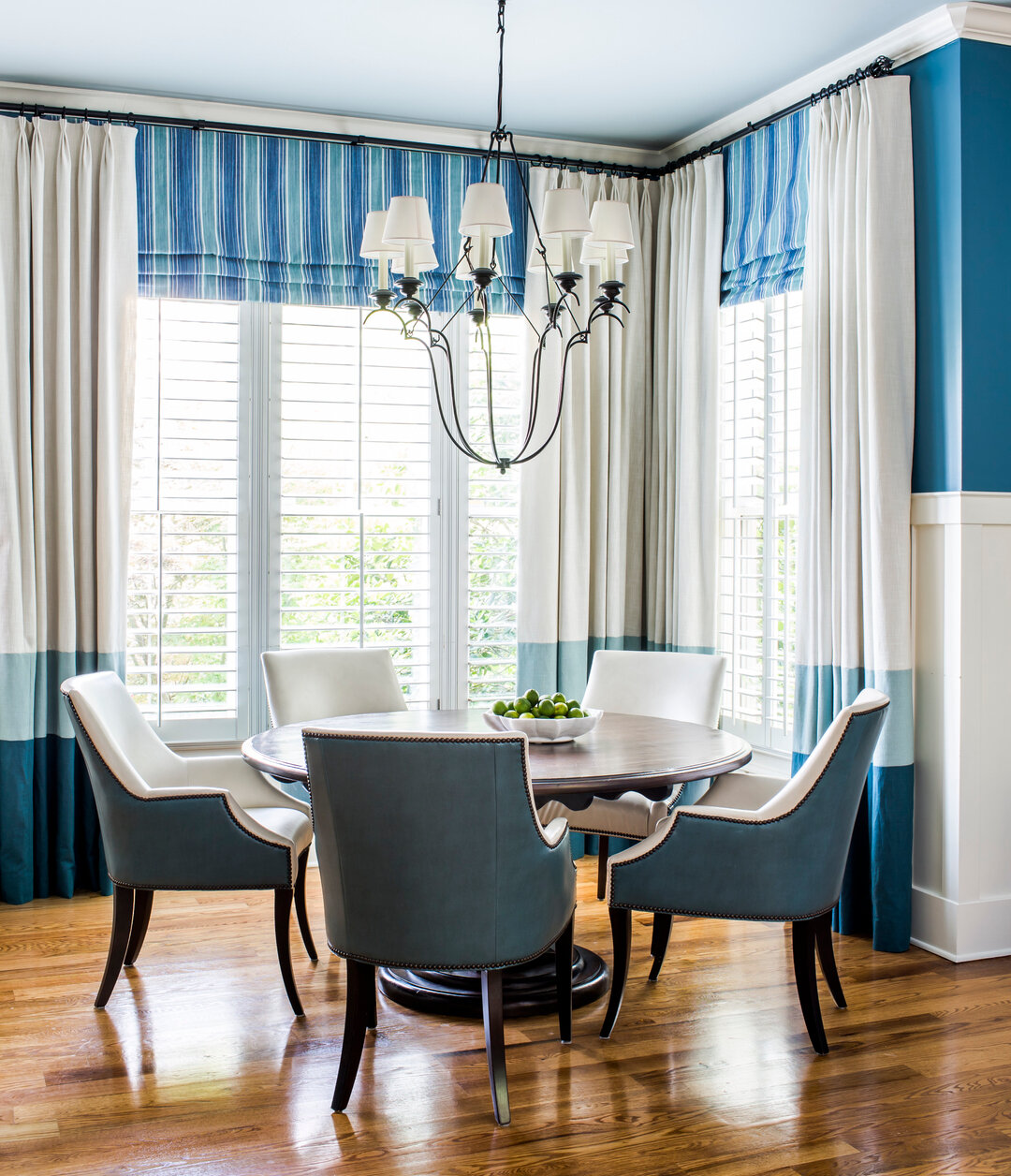 This client loves COLOR and wasn't shy to allow it to be used. The Color block window panels tie together with the blue wall color and the stripe shades add loads of brightness and interest. I love a round dining table, it makes you want to sit and s