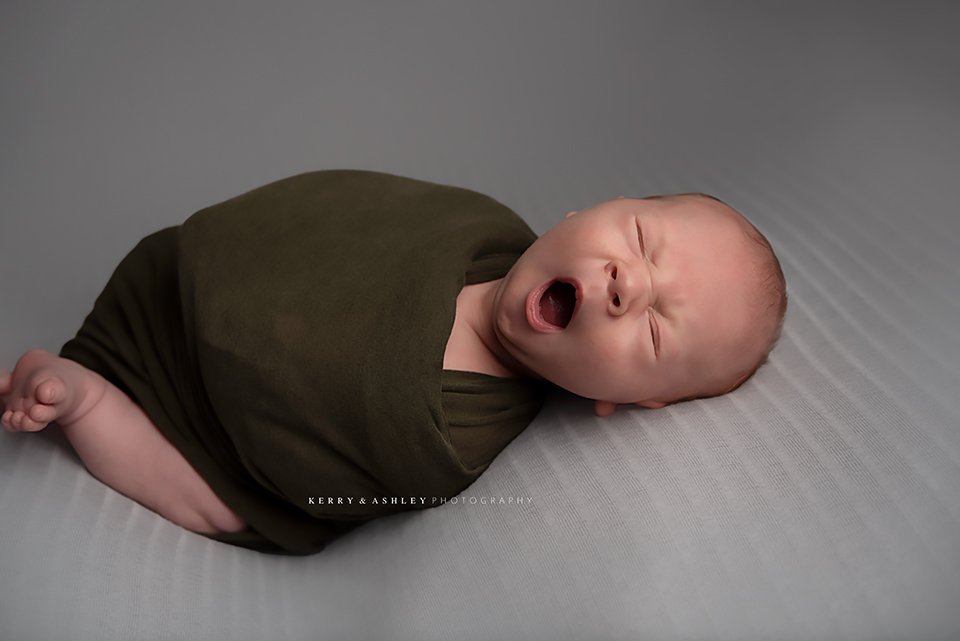 baby-yawning-grey-backdrop.jpg