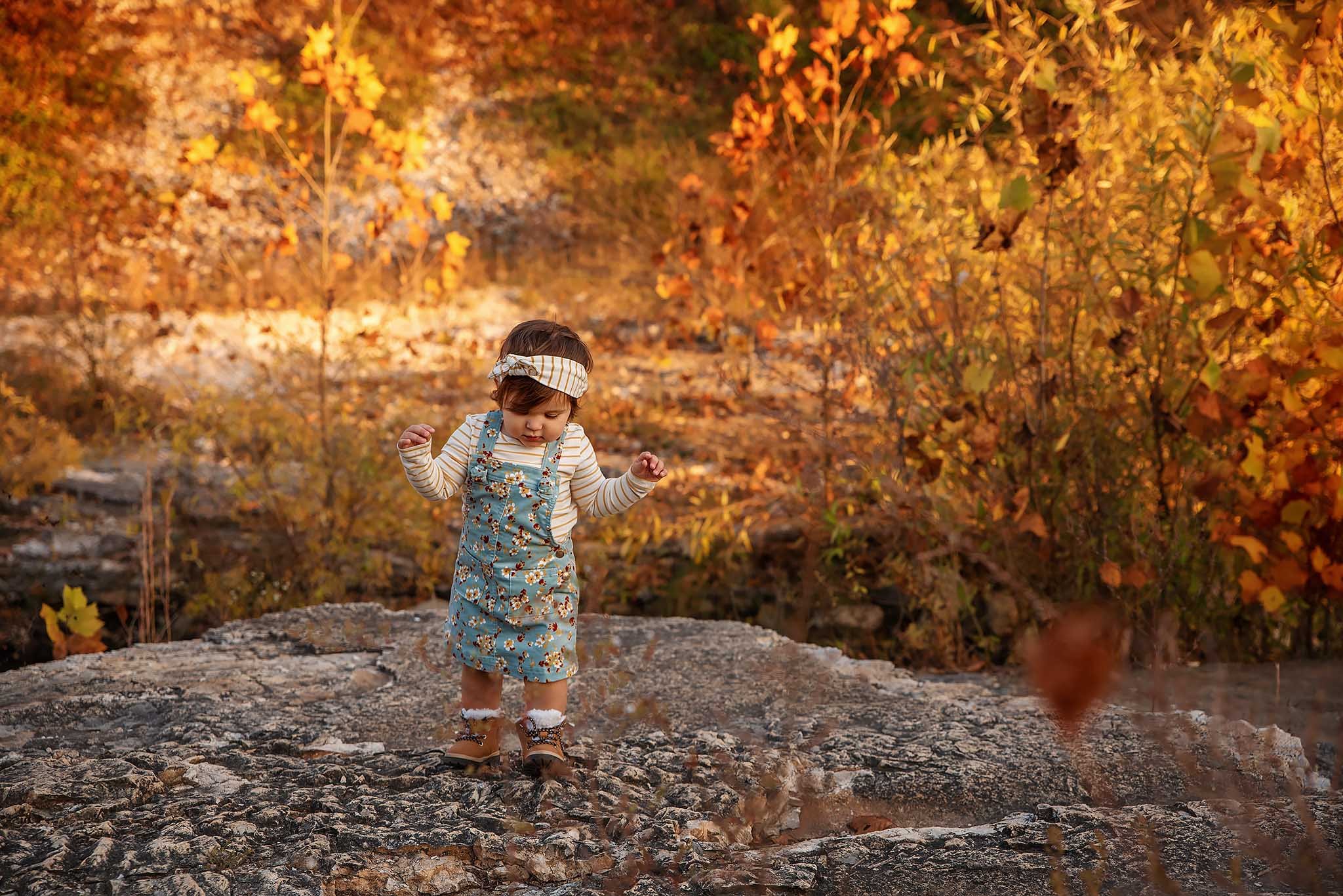 toddler-standing-on-rock-in-fall-foliage.jpg