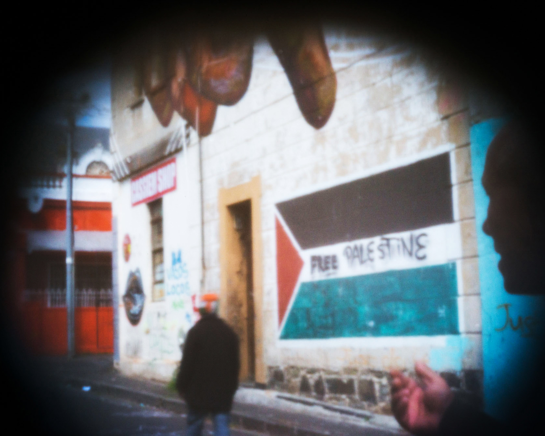 Two Woodstock residents converse beneath graffiti on the wall of Cassiem Corner Shop. The graffiti was created by Gia, a graffiti artist from New York.