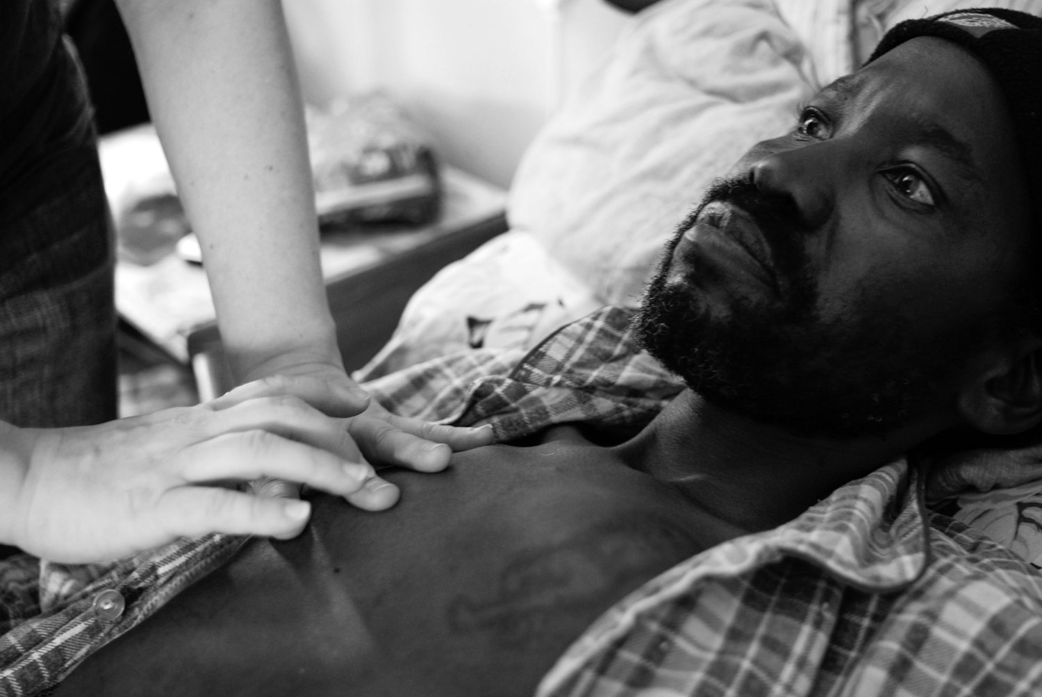 This patient had been bedridden within the treatment centre for over 6 months due to a combination of opportunistic infections and tuberculosis. After returning home for a brief period he returned he returned where I photographed him being examined