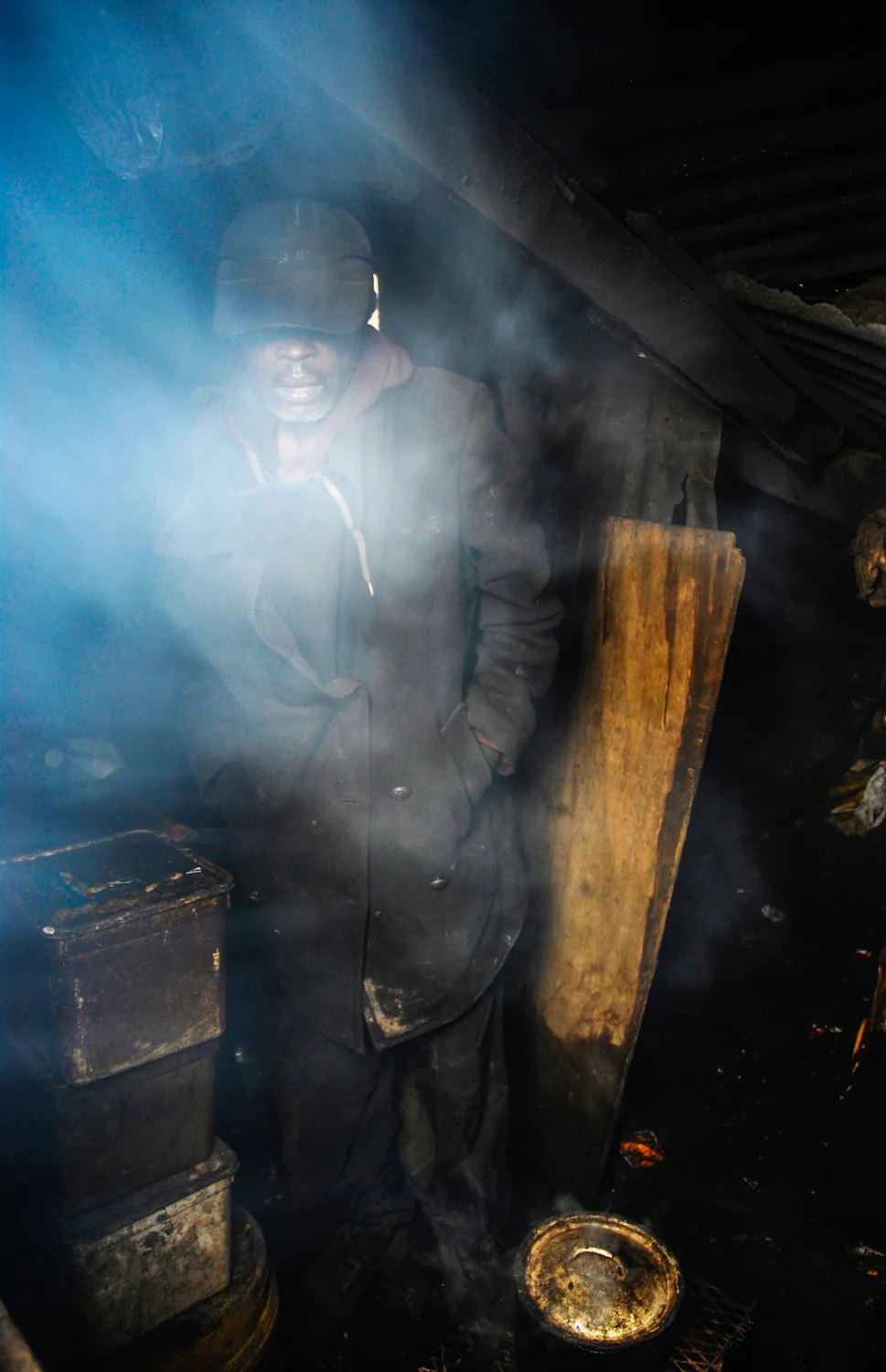 Edward huddles next to his wood burning stove during a storm