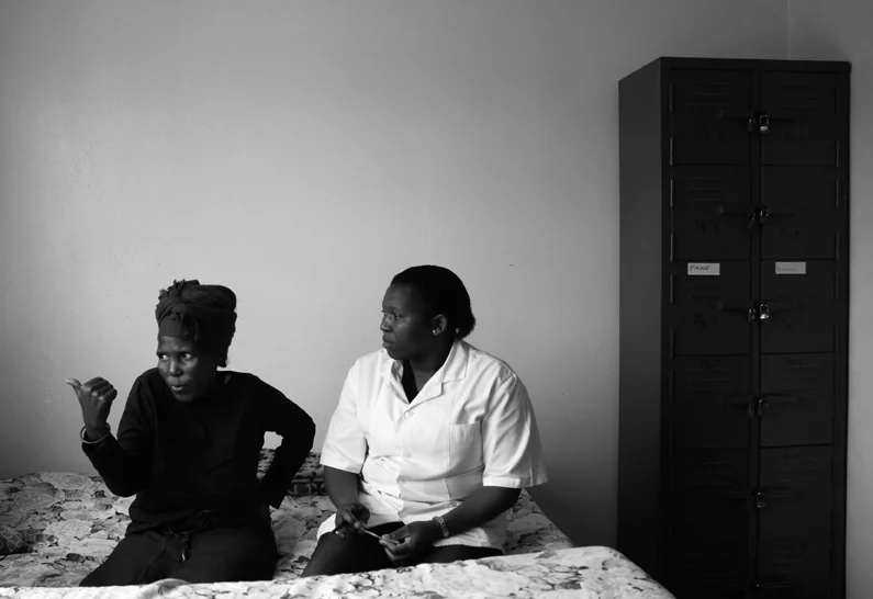 Treating HIV & AIDS is not confined to the physical and medical; another integral aspect is psychological counselling for all those living with the virus from the patients themselves to their family members and partners. Here, Babalwa, an orderly at the treatment, counsels a Fezeka, whose husband has been diagnosed with HIV. Fezeka will also need to undergo testing to see if she has become infected. It is emphasised that with antiretroviral treatments it is possible to live a life just as if one was not infected.
