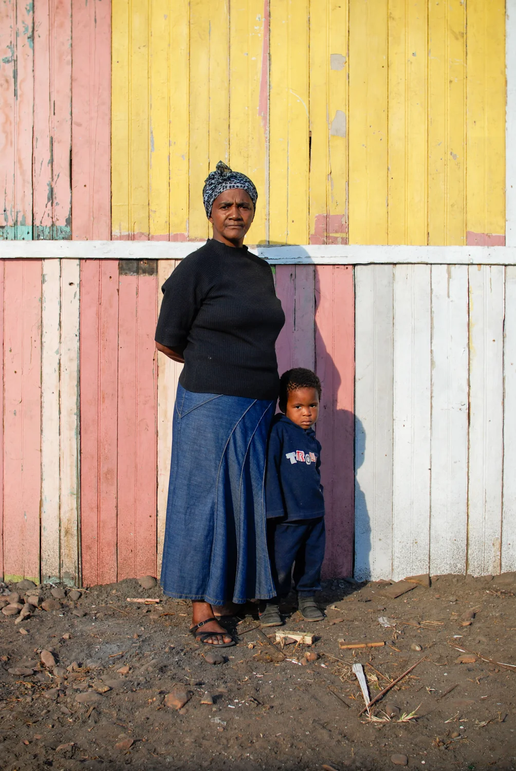 Thembisa and her son stand next to her newly built home