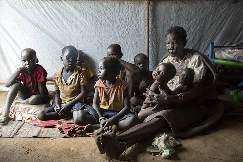 A grandmother sits with her nine grandchildren at a refugee camp in South Sudan, Ilana Rose for World Vision