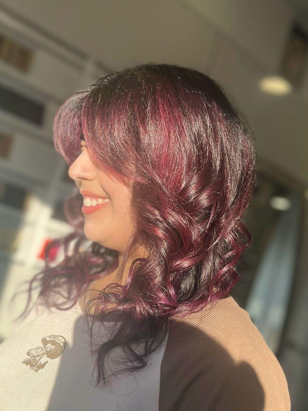 Stepping into the spotlight with a burst of plum perfection! 🍇💫 

Our client's shoulder-length hair, adorned with curls and face-framing layers, is a masterpiece in every strand. Ready to unveil your own glamorous transformation? Click the link in 