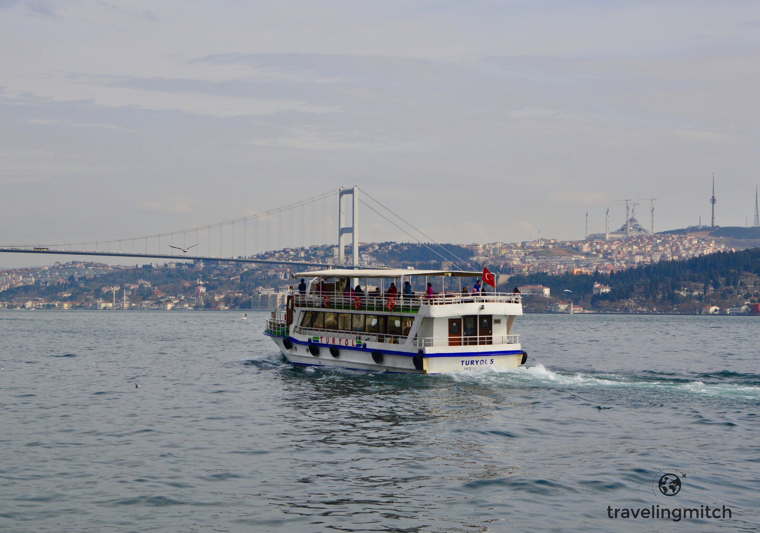 A tourist boat politely chugs along the Bosphorus near Örtaköy, Istanbul, Turkey
