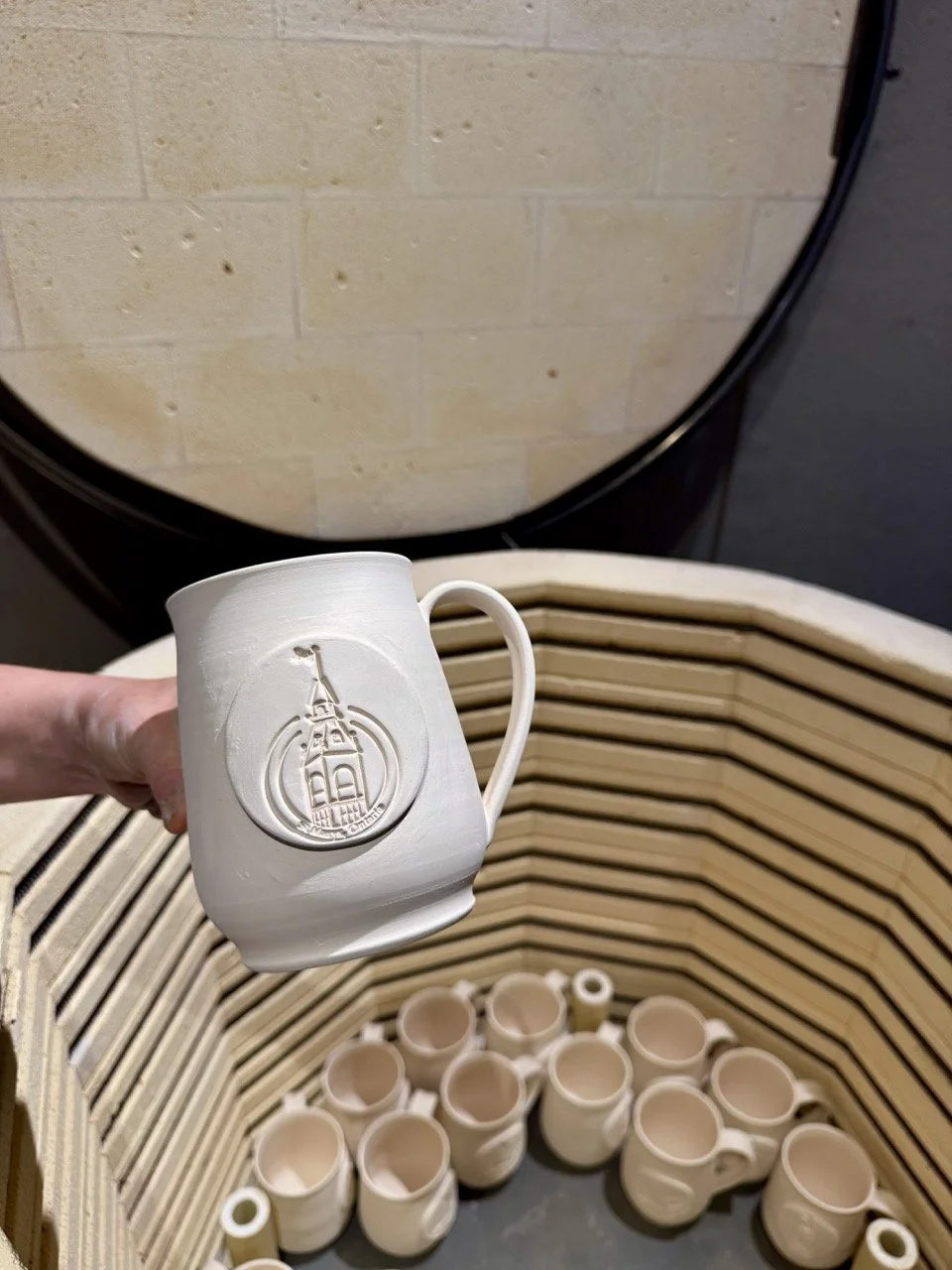 One of the St. Marys mugs being fired in the kiln at Zenfire