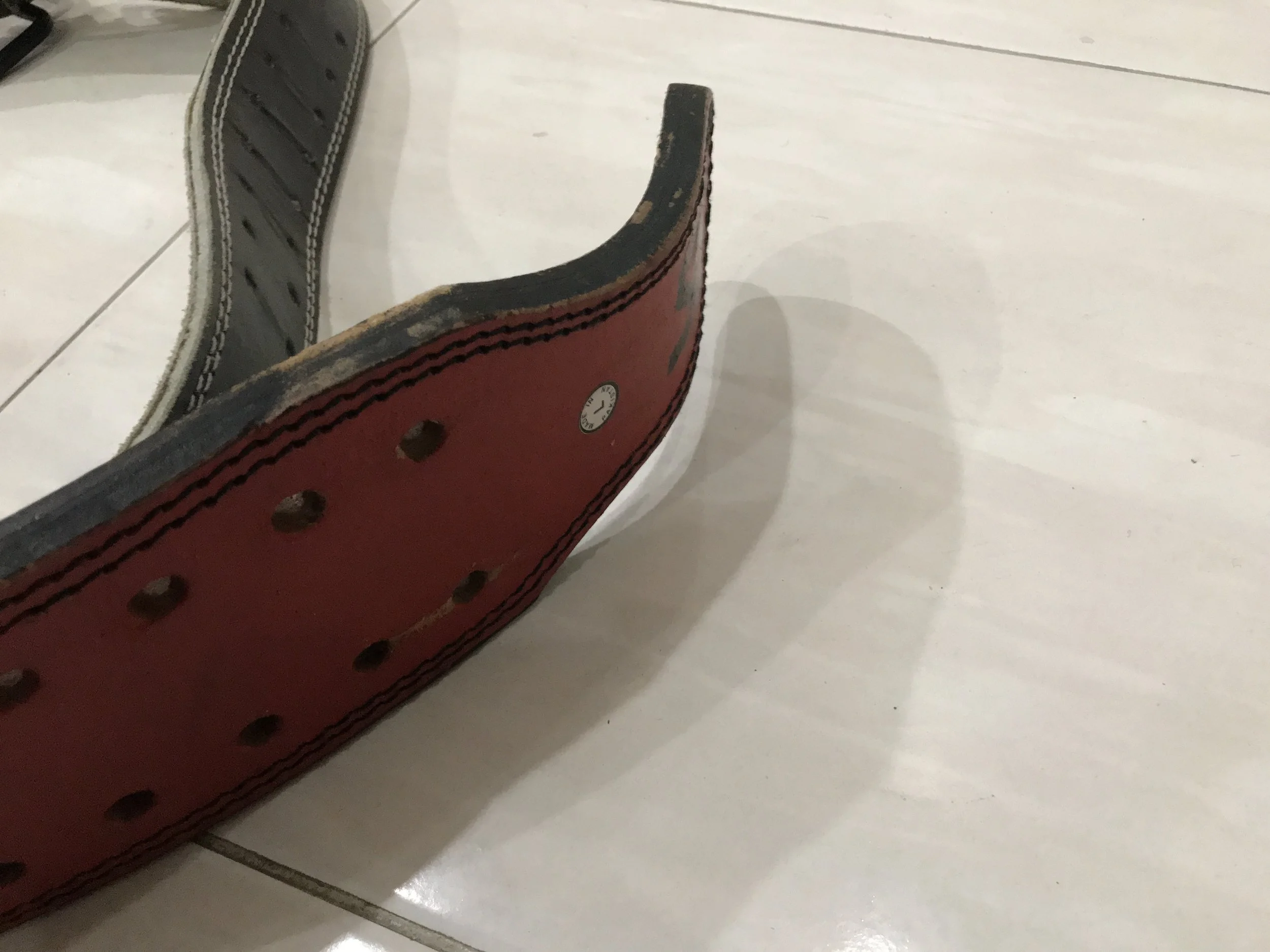 The scuff marks on the old belt rubbing agains the loop can be appreciated. I hook the old belt into the third pair of holes and the new belt into the second pair.