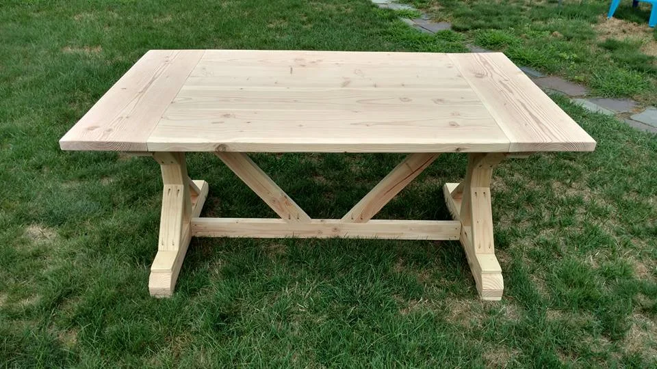 Unfinished trestle style table with bread board ends
