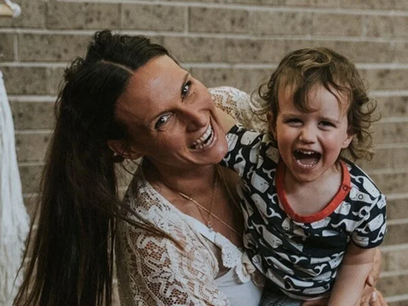 Nancy holding a smiling young Henley during Yoga Playgroup