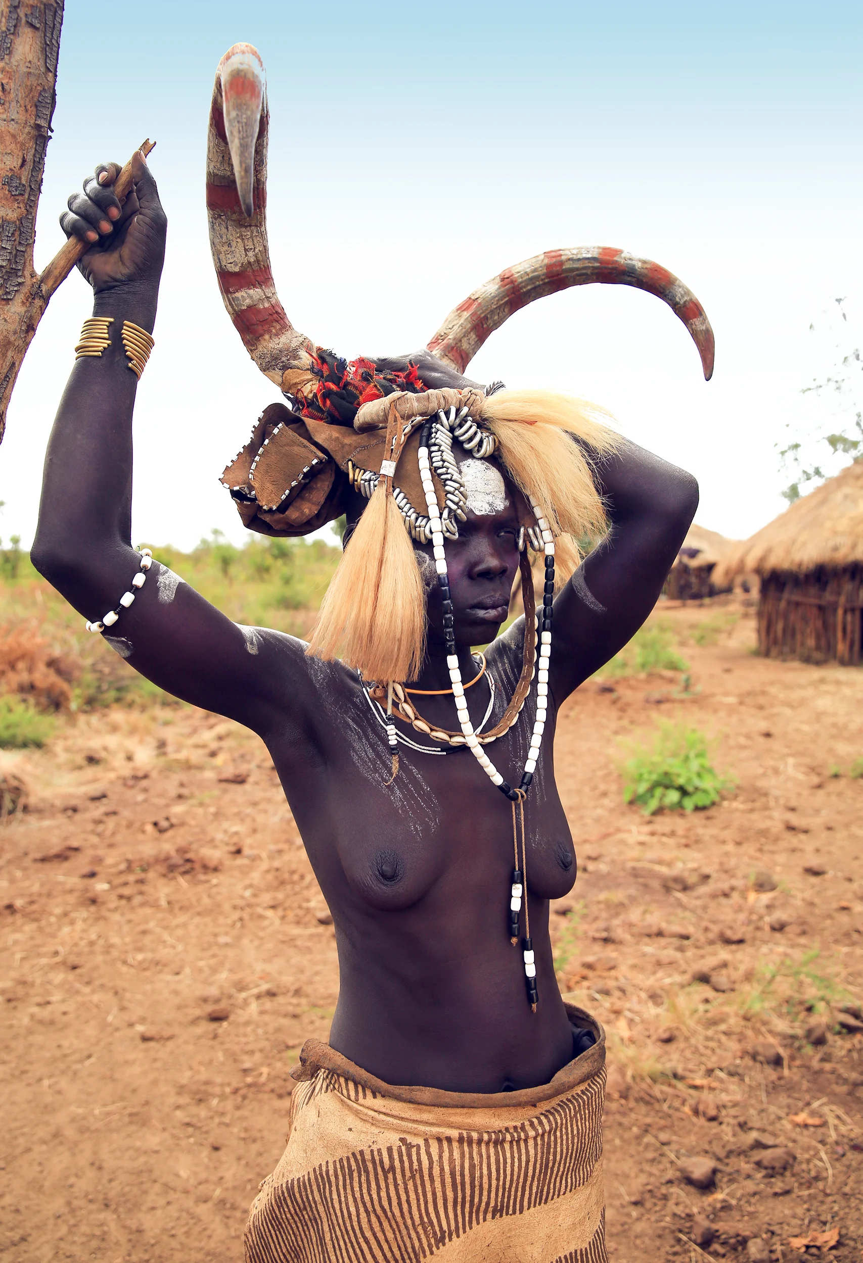 Mursi women are considered beautiful if they have a big lip plate and scarifications. Piercing and lip plates are a strong part of the culture. These traditional adornments are worn by almost all of the adult women. When a Mun (as they call themselves) becomes engaged to be married, usually around 14 or 15, she disappears from village life to live in her family hut. The gap between her front lip and the flesh below is pierced and gradually stretched. In the beginning a hole is made in the lip with a wooden stick. The stretching continues as successively bigger discs of clay or wood are accommodated by the changed lip. Generally the two lower front teeth are pulled or knocked out to aid in the process. The final size of the plate helps to determine her beauty & bride price.