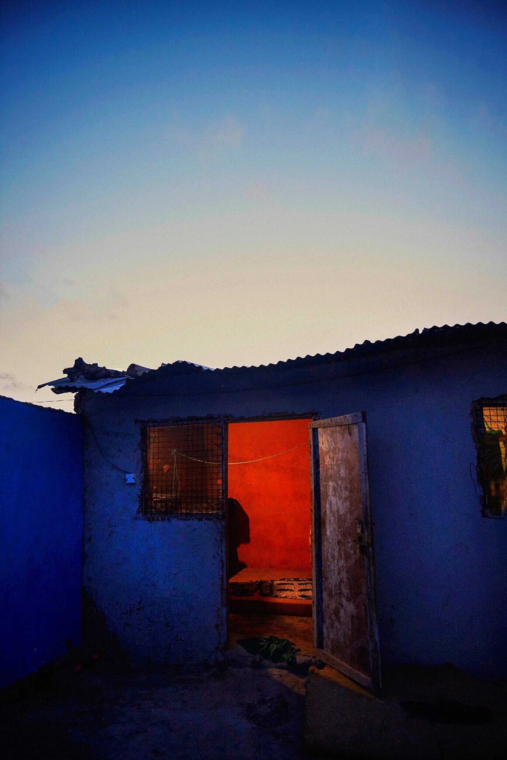  The sun sets behind a corrugated roofed room where women sleep and service clients 