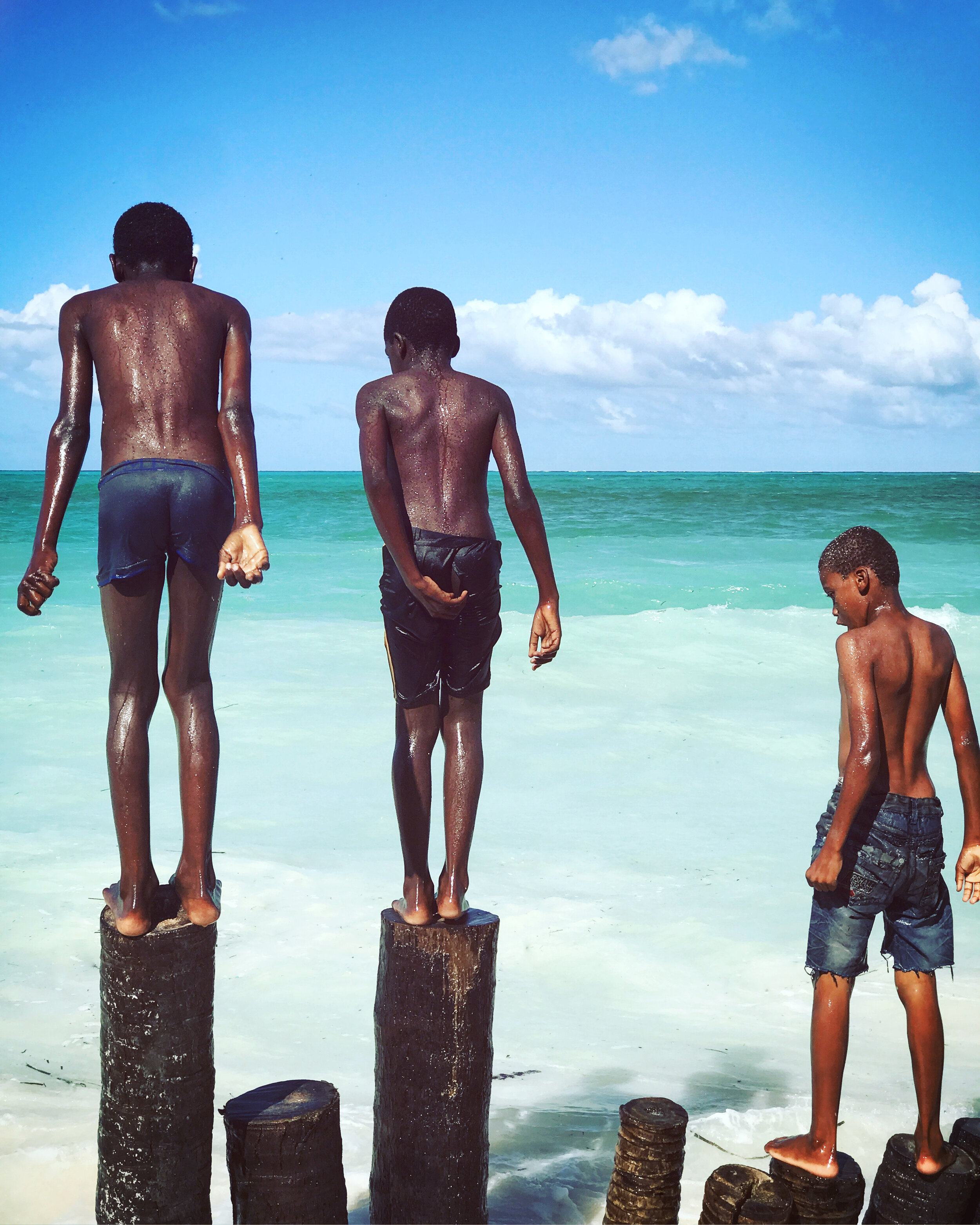  Boys use pile-ons, meant to dissipate the force of the ocean’s waves, as diving posts    Zanzibar 