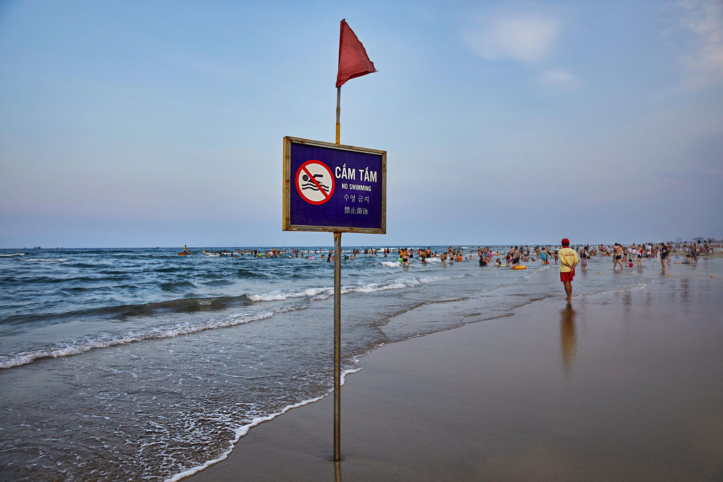  No swimming sign at My Khe beach in Da Nang, Vietnam.  By May, lulled by notions that the country had completely beaten Covid-19– with its stringent lockdowns, early mandated mask-wearing, and contact tracing–people in this city, returned to their w