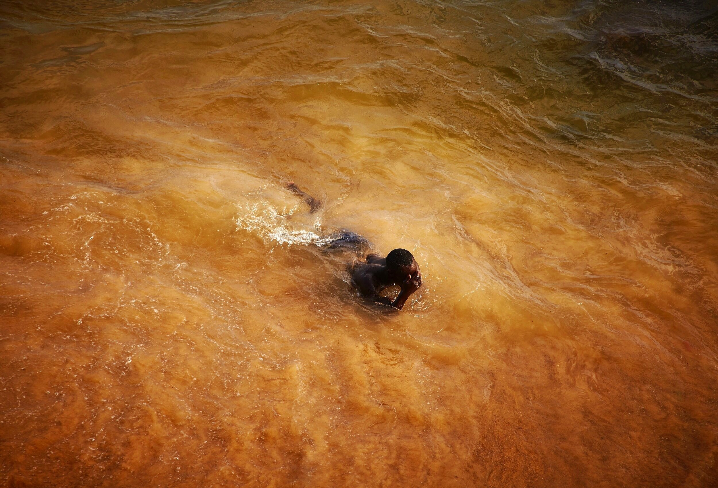  Babacar Diallo swims in the ocean in Saly, Senegal 