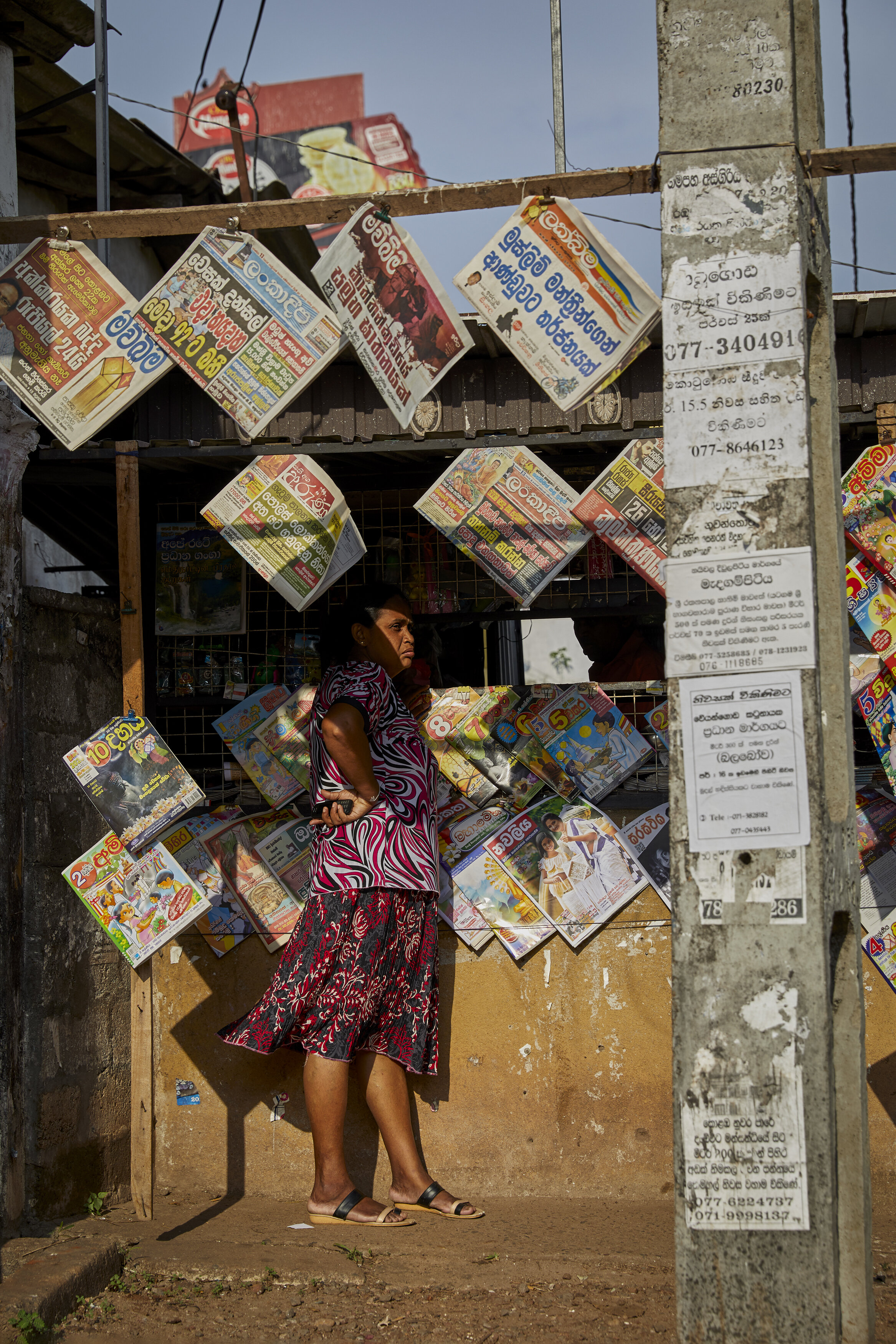  A woman stands at a newsstand days after the Easter Sunday Bombings, with headlines that decry the tragedies. In retaliation for the bombings, people began looting mosques and Muslim-run businesses, with a nationwide curfew enacted for weeks to try 