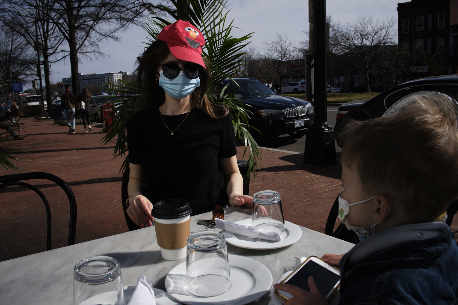  Kathleen  sits with her 3 year old son, Gabriel at an outside restaurant waiting for a cup of coffee for take-away in Washington,DC. Kathleen is a single mother who works full time from home. Due to the Covid-19 pandemic, she has no childcare help ,