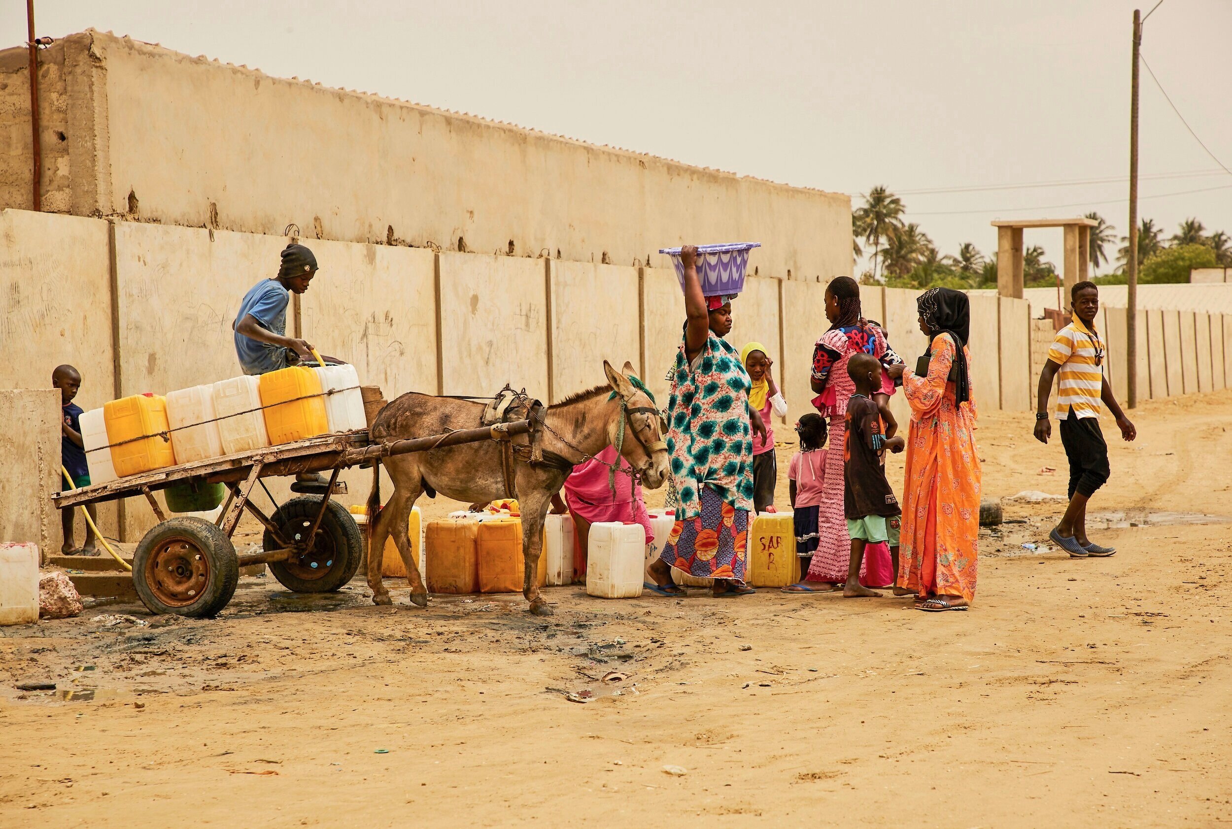  Residents of Khar Yalla camp– the “temporary” site where people whose homes have been destroyed are relocated– queue for water.  The arid land at the camp is not connected to sufficient water lines, so people must collect it from a single tapped sou