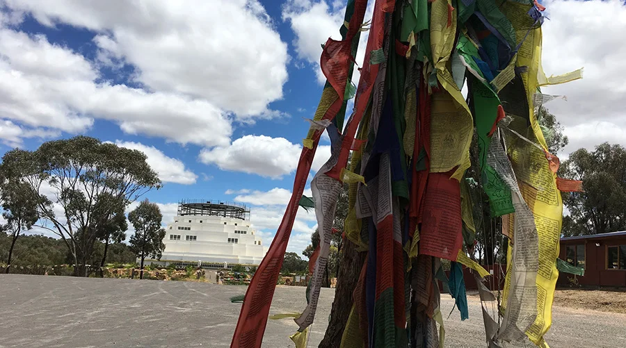 View of the Stupa through wind-whipped prayer flags - photo by Catherine Schieve