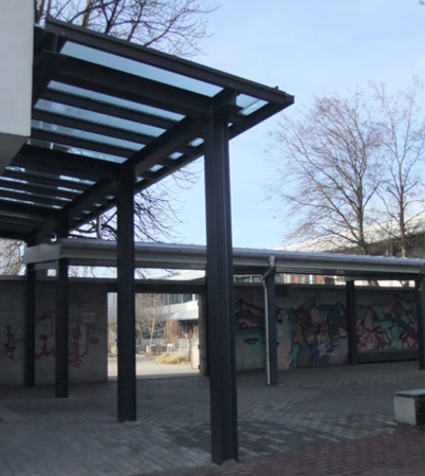 Das Gymnasium Grafing wurde in den 1960er Jahren erbaut und besteht aus 4 verschiedenen Gebäudeteilen. Ein Verbindungsgang zwischen Atriumsgebäude und Langhaus bildet gleichzeitig den Haupteingang zur Schule. Dieser Verbindungsgang war baufällig und
