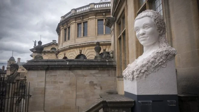 This pair of sculptures in plaster of Paris was installed outside the Museum of History of Science during June-July 2019 as part of the ‘Tomorrow’s Oxford Heads’ exhibition - celebrating the 350th anniversary of the creation of the original famous Sheldonian Theatre heads in Oxford. The temporary installation, intended to mirror the silhouette of the original heads, imagines what contemporary carved heads could look like in Oxford in the context of a diverse, multicultural city sadly lacking in diversity in its permanent public sculpture.