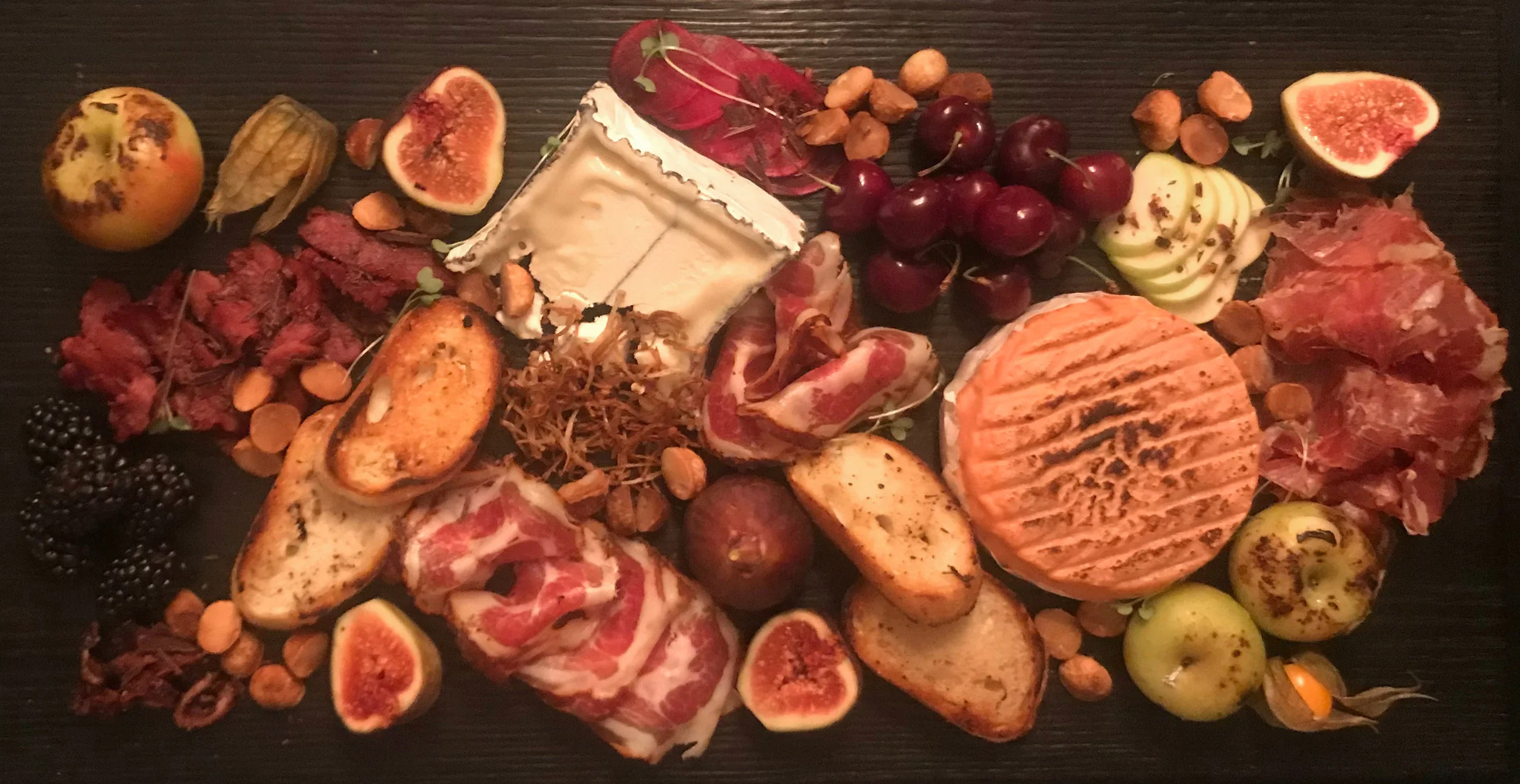 Charcuterie board 1: Epoisses &amp; Humbolt Fog, with Hudson valley cured meats and fruits, french regional smoke duck and local farmed mustard greens. For wine, we've paired in a Zola white Cotes Du Rhone.