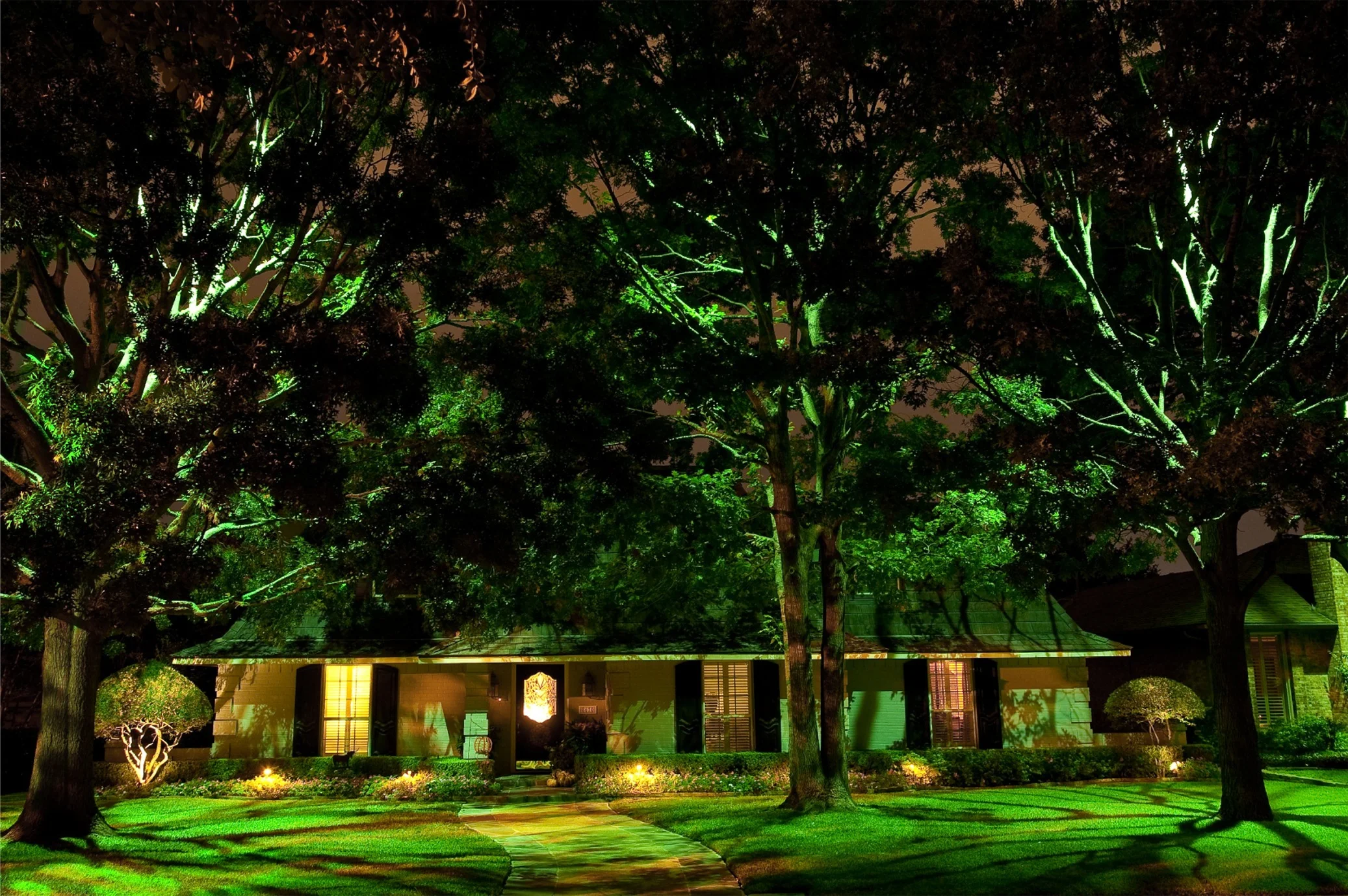 Create moonlighting techniques by placing a large fixture with a full glare guard high up inside a tree, and angled downwards. This effect looks like moonlight shining down through the branches. It causes attractive shadow patterns on the ground to appear, plus it provides a very natural and beautiful lighting effect.