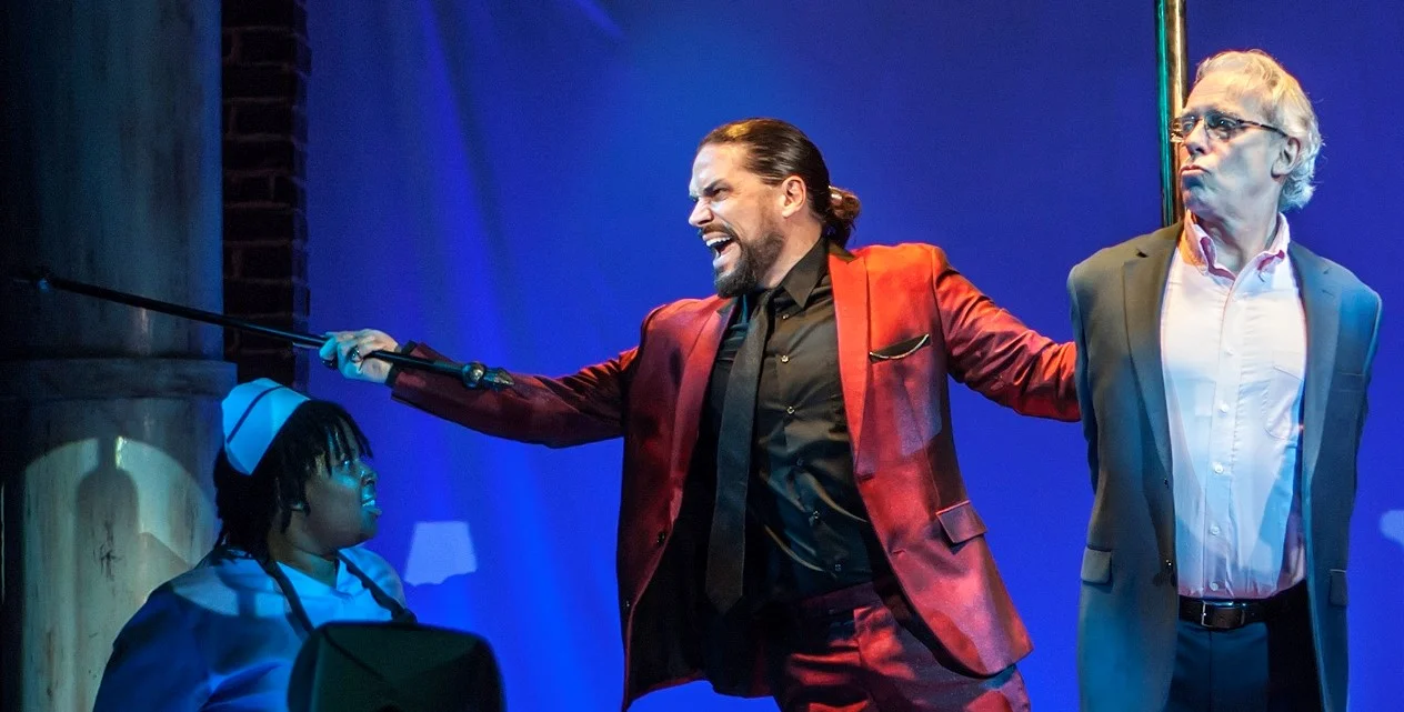 Will Swenson (left) as a swaggering Satan and Terrence Mann as Jerry Springer in Jerry Springer: The Opera . Top: Mann with Florrie Bagel and Luke Grooms as a couple with issues.