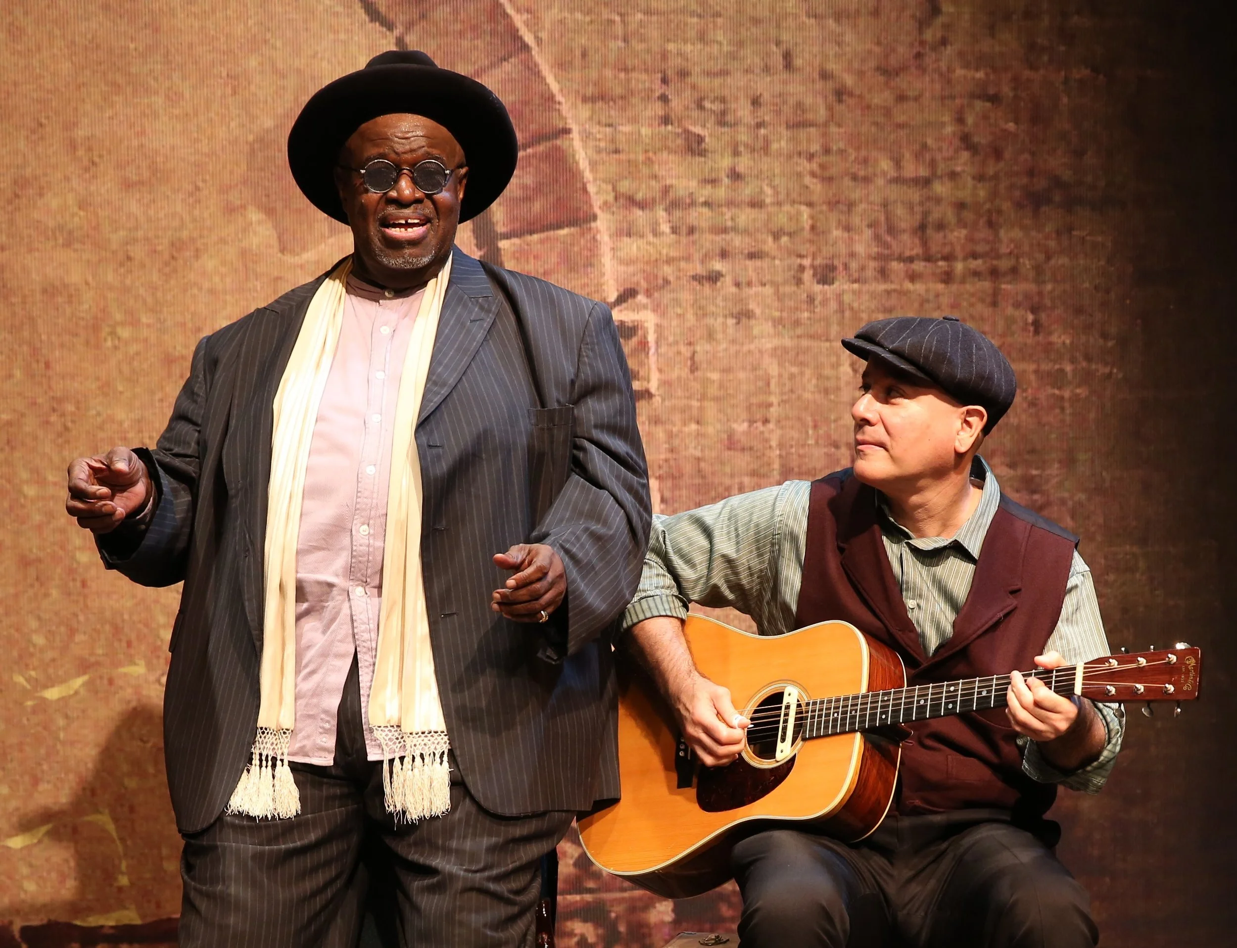 Akiń Babatundé (left) as the prolific, itinerant Texas bluesman Blind Lemon Jefferson, with David Weiss on guitar. Top: Babatundé as Jefferson. Photographs by Carol Rosegg.